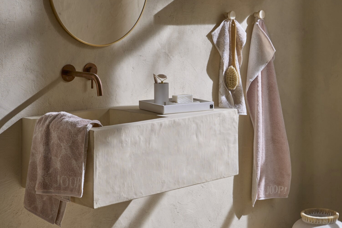 Helles, mediterranes Badezimmer mit Hängewaschbecken und Handtüchern der JOOP!-Serie Cornflower in Rosa