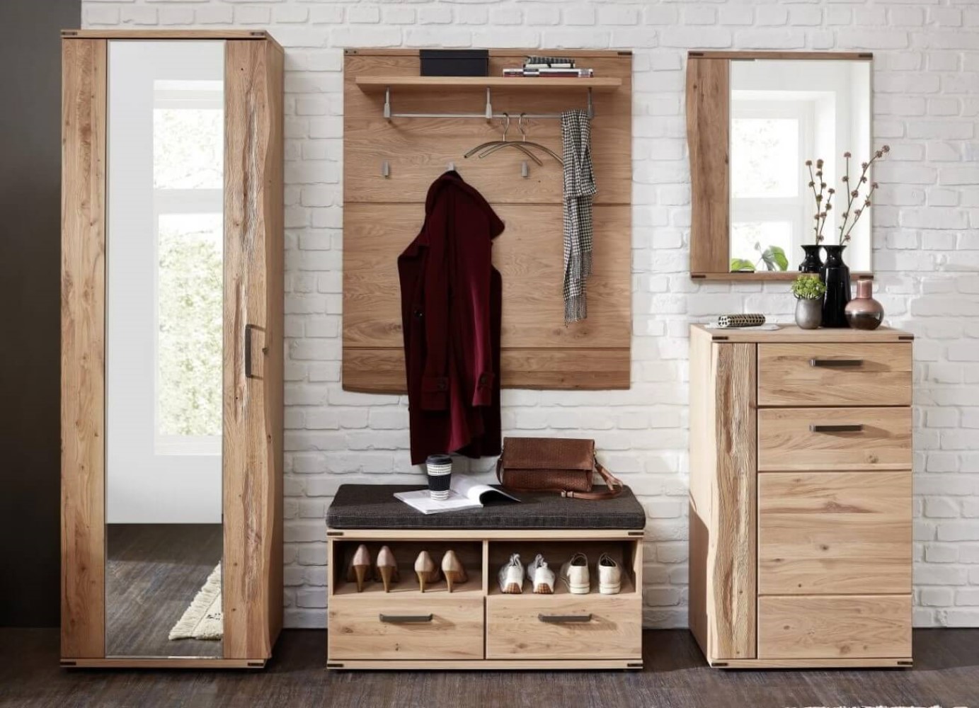 Moderner Eingangsbereich mit Holzmöbeln, darunter ein Spiegelschrank, Schuhlager, Garderobe und ein Schrank, vor einer weißen Ziegelwand.