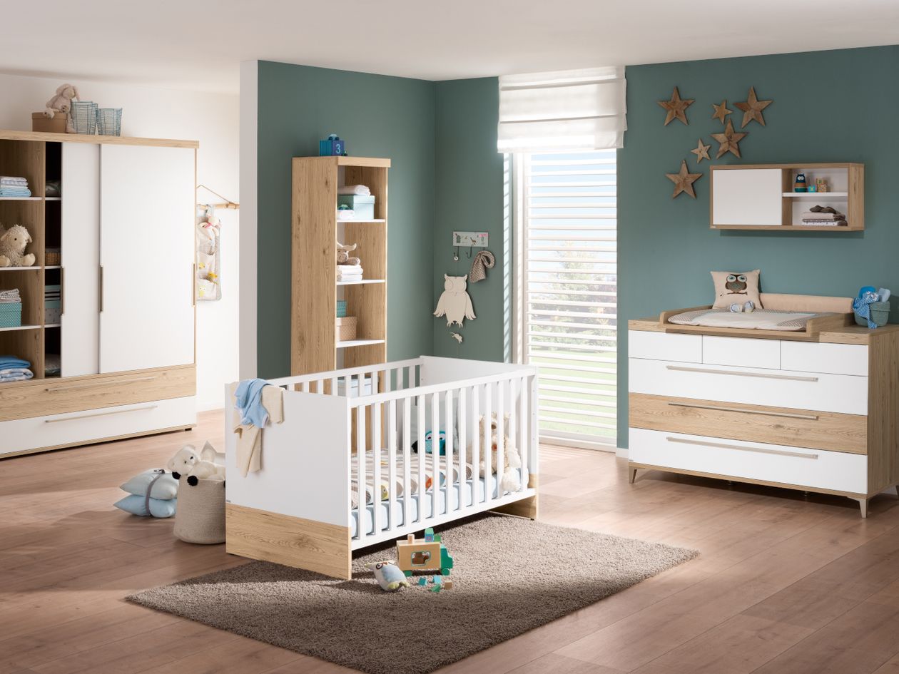 Ein Babyzimmer mit petrolfarbenen Wänden, eingerichtet mit den weißen Möbeln der Paidi Serie Remo mit Elementen in Eiche-Bordeaux-Nachbildung.
