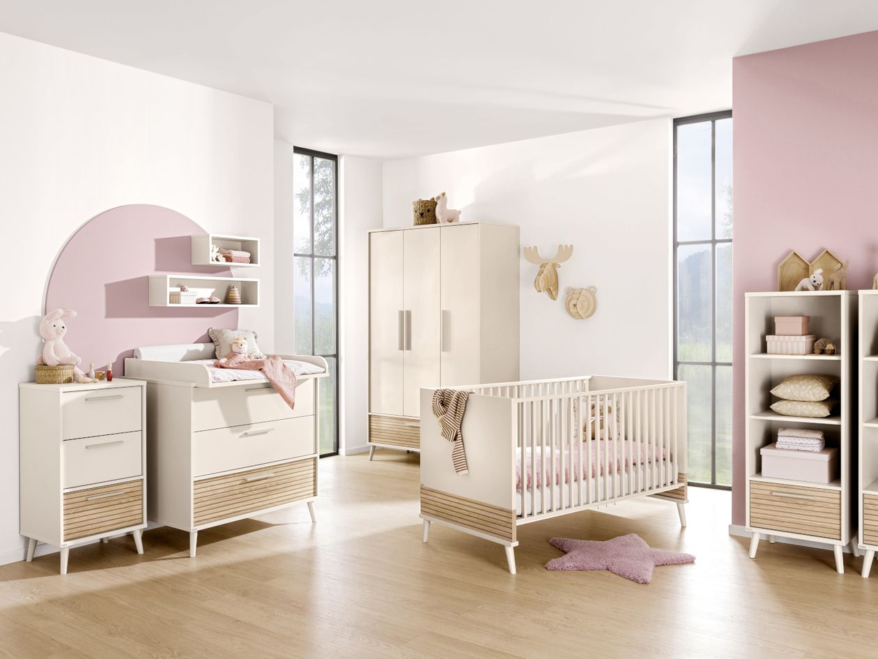 Ein Babyzimmer mit Holzdeko und Rosa Akzenten eingerichtet mit den beigen Möbeln der Paidi Serie Eefje mit Absetzungen in Eiche Lamellenoptik.
