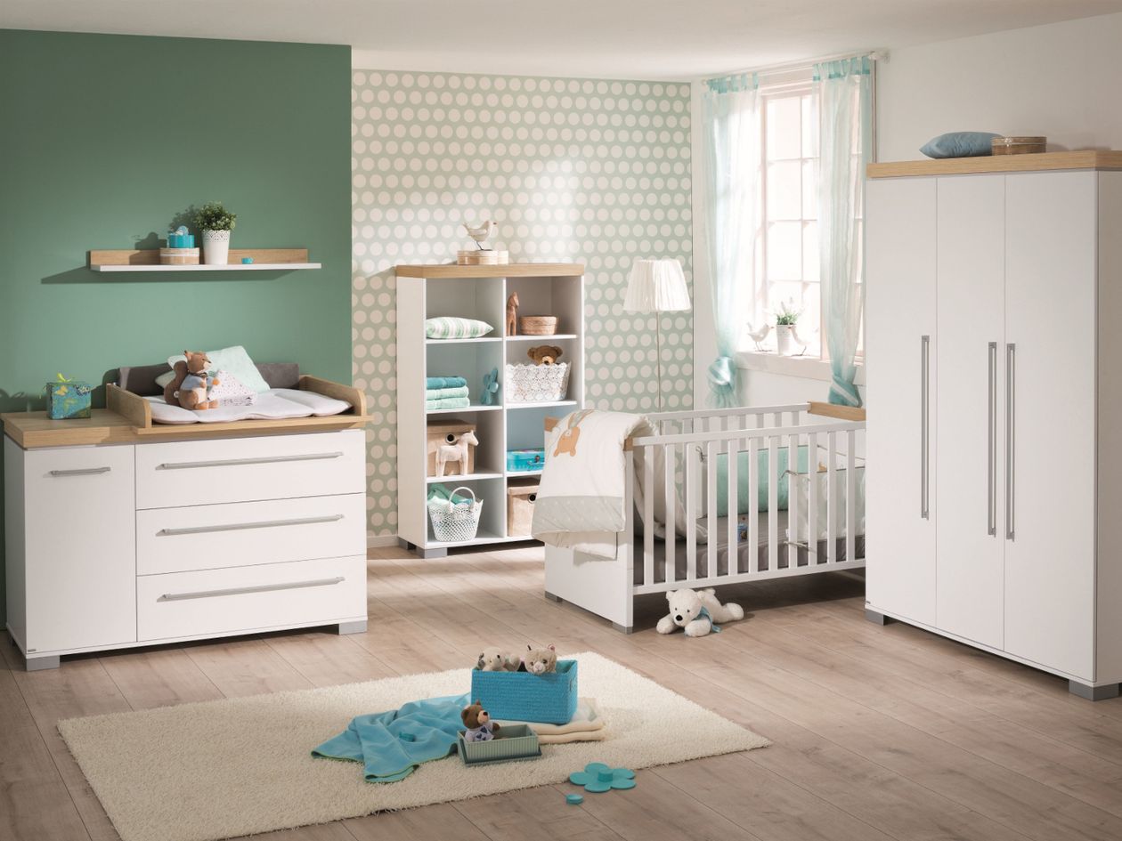 Ein Babyzimmer eingerichtet mit den weißen Möbeln der Paidi Serie Kira. Ein Teil der Rückwand ist grün.