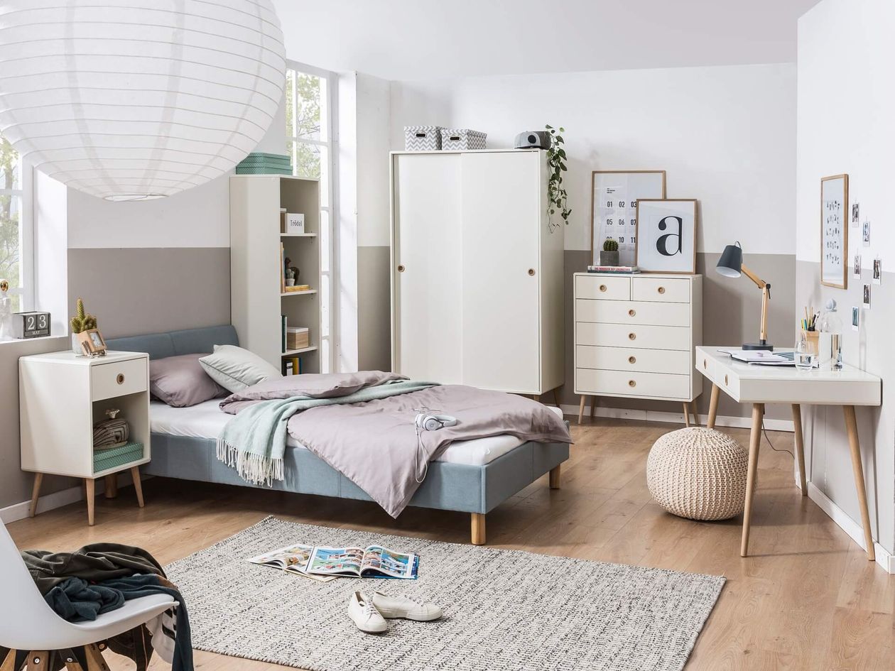Modernes Schlafzimmer mit minimalistischem Design, ausgestattet mit Bett, Kleiderschrank, Schreibtisch und Dekor in neutralen Tönen, mit natürlichem Licht durch große Fenster.