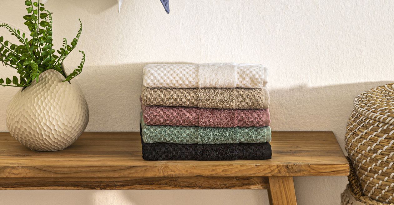 Die Satin-Bettwäsche Anna von Fürstenhof in Weiß, Creme und Anthrazit auf einem Bett