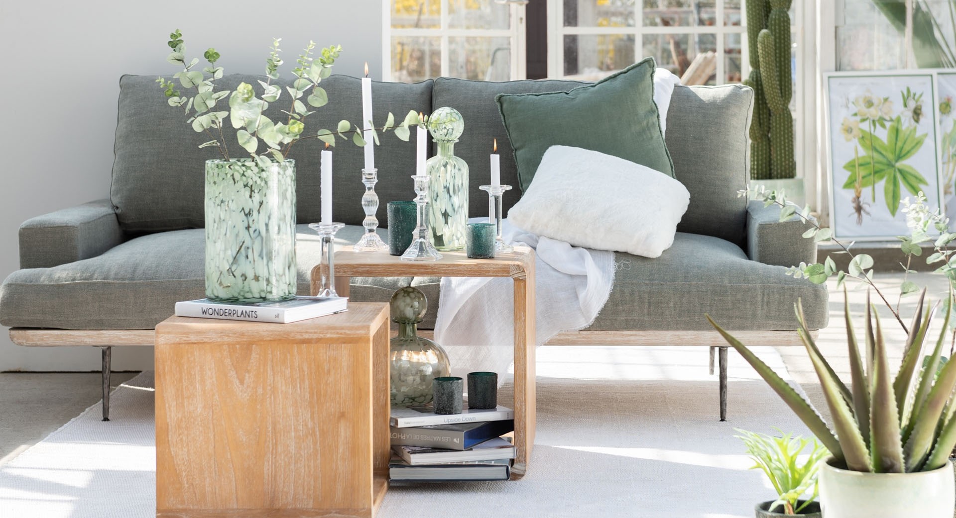 Kissen in der Größe 45 x 45 Zentimeter der Marke Daheim in grünem Leinen auf einer grauen Couch