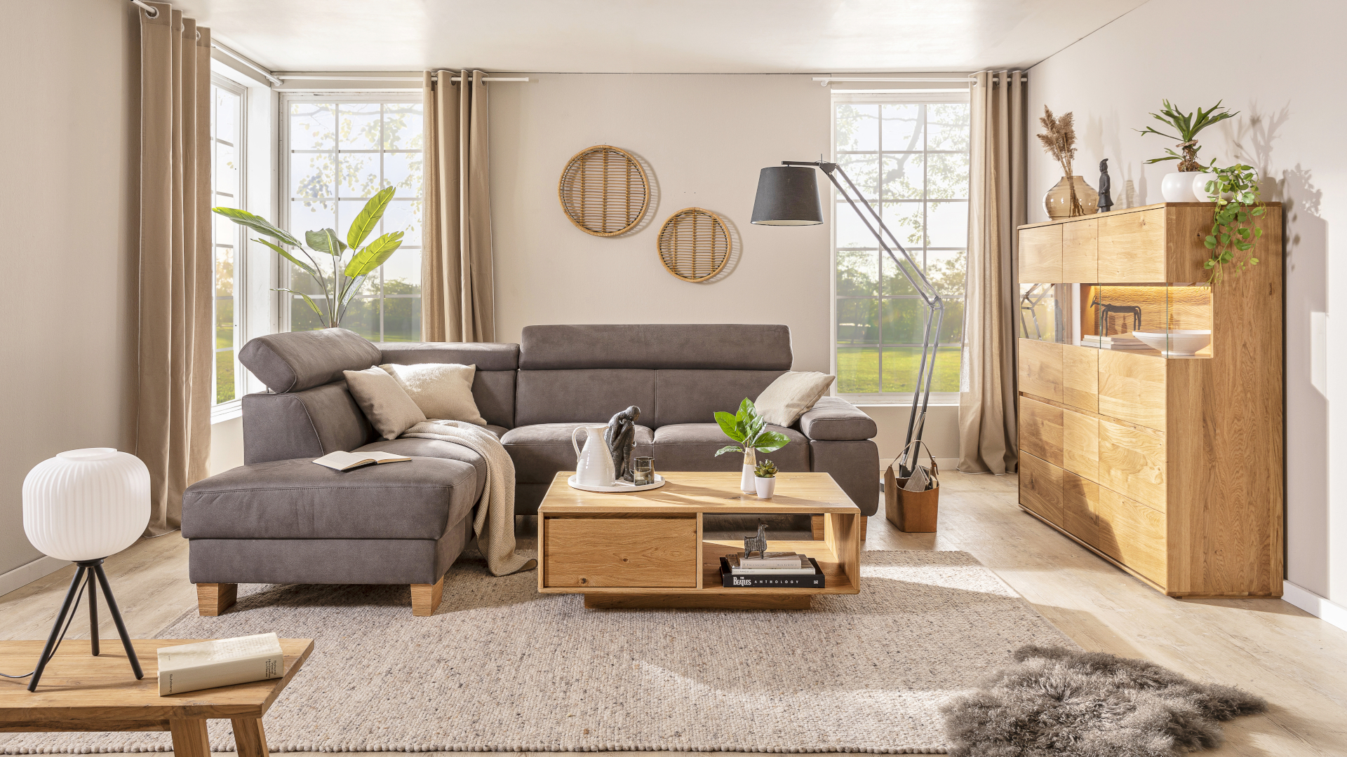 Das Ecksofa Tampa von Maison in Braun mit Holzfüßen in einem Wohnzimmer, dass mit Holzmöbeln der Marke eingerichtet ist.