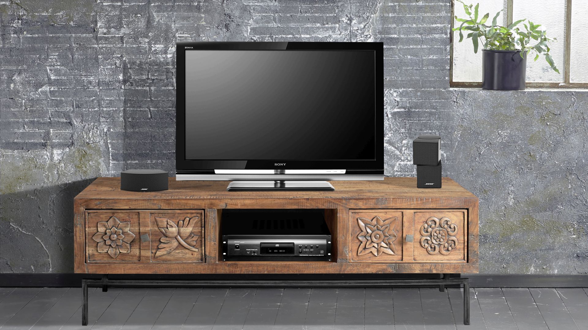 Das TV-Lowboard Carving von Wolf Möbel fällt vor allem durch die dekorativen Motive, die in die Schubladen aus Akazienholz geschnitzt wurden, auf.
