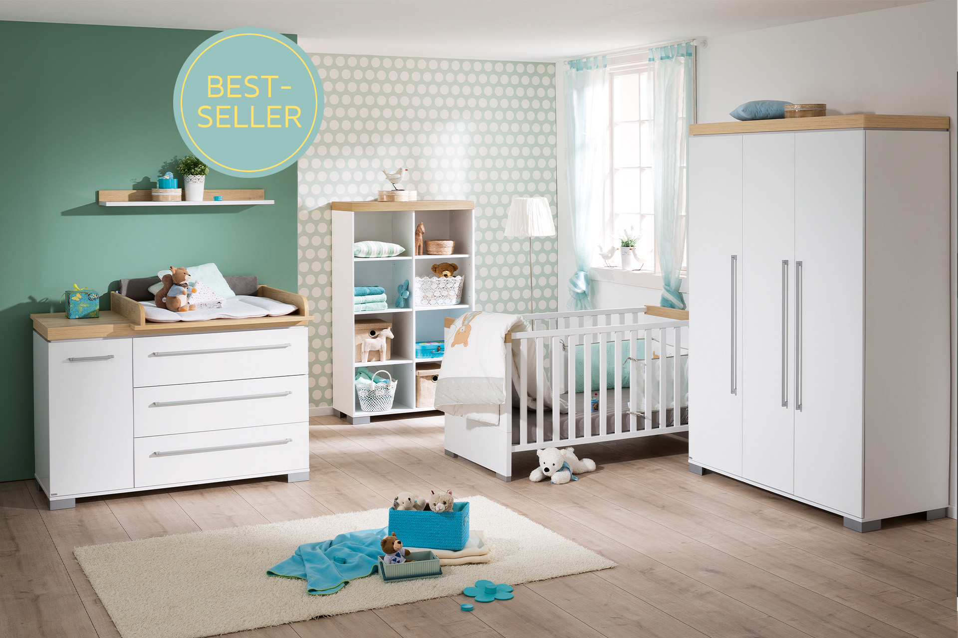 Ein Babyzimmer eingerichtet mit den weißen Möbeln der Paidi Serie Kira. Ein Teil der Rückwand ist grün.