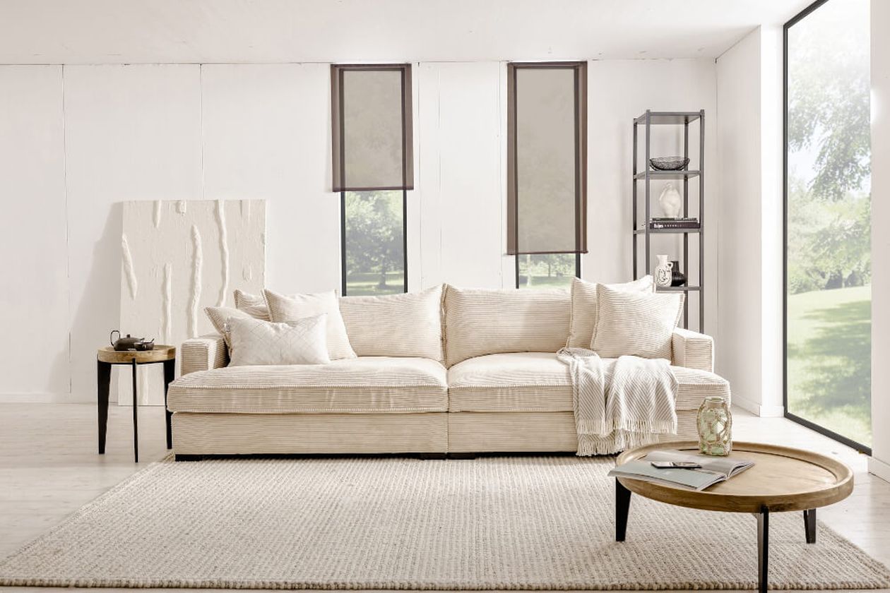 Bigsofa Tribecca aus dem Hause Booom mit Cordbezug in Cream in einem in nüchternem Scandistil eingerichteten Wohnzimmer