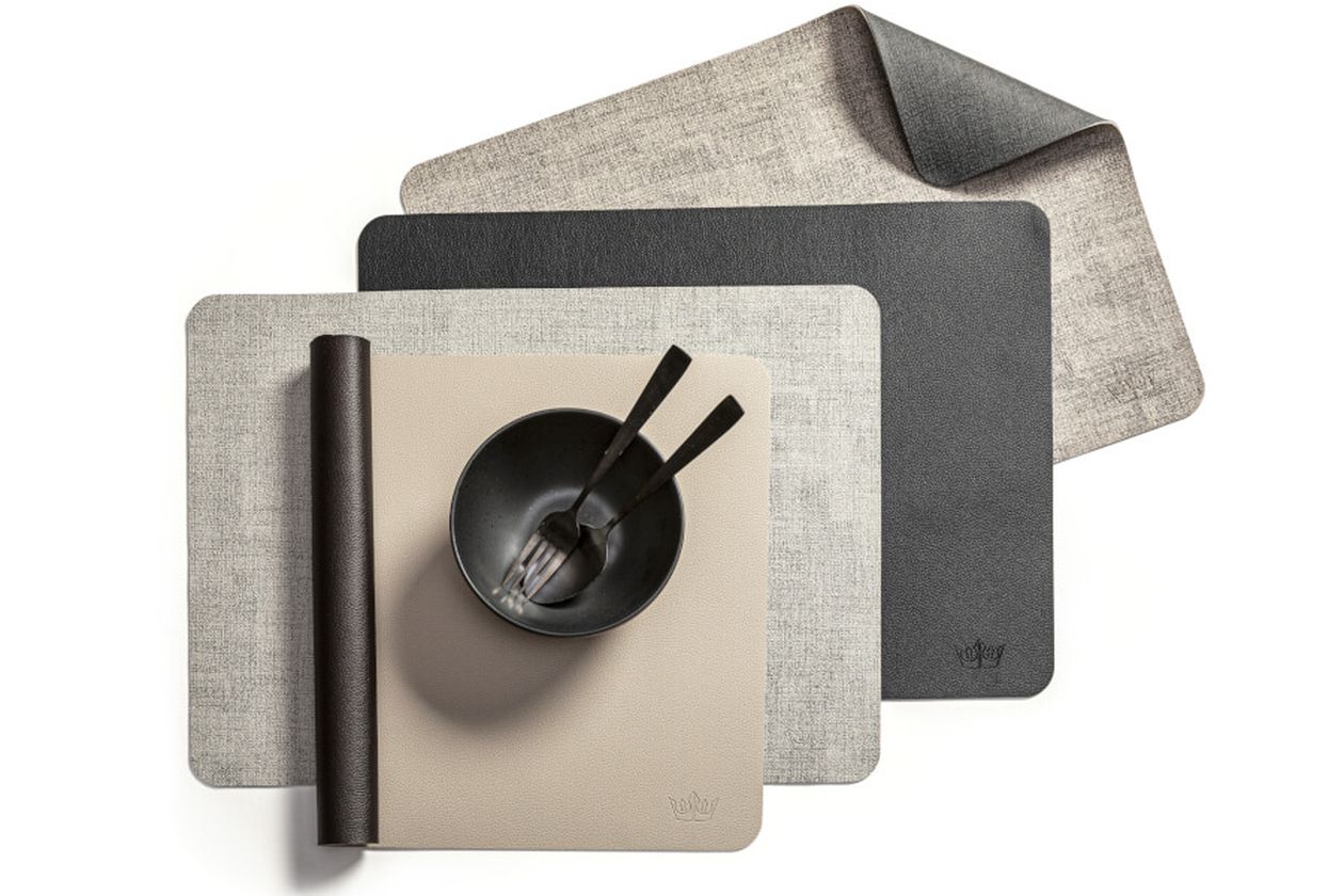 Eine schwarze Schale mit Besteck steht auf verschiedene Fürstenhof Tischsets in den Farben Beige, Hellgrau und Dunkelgrau.