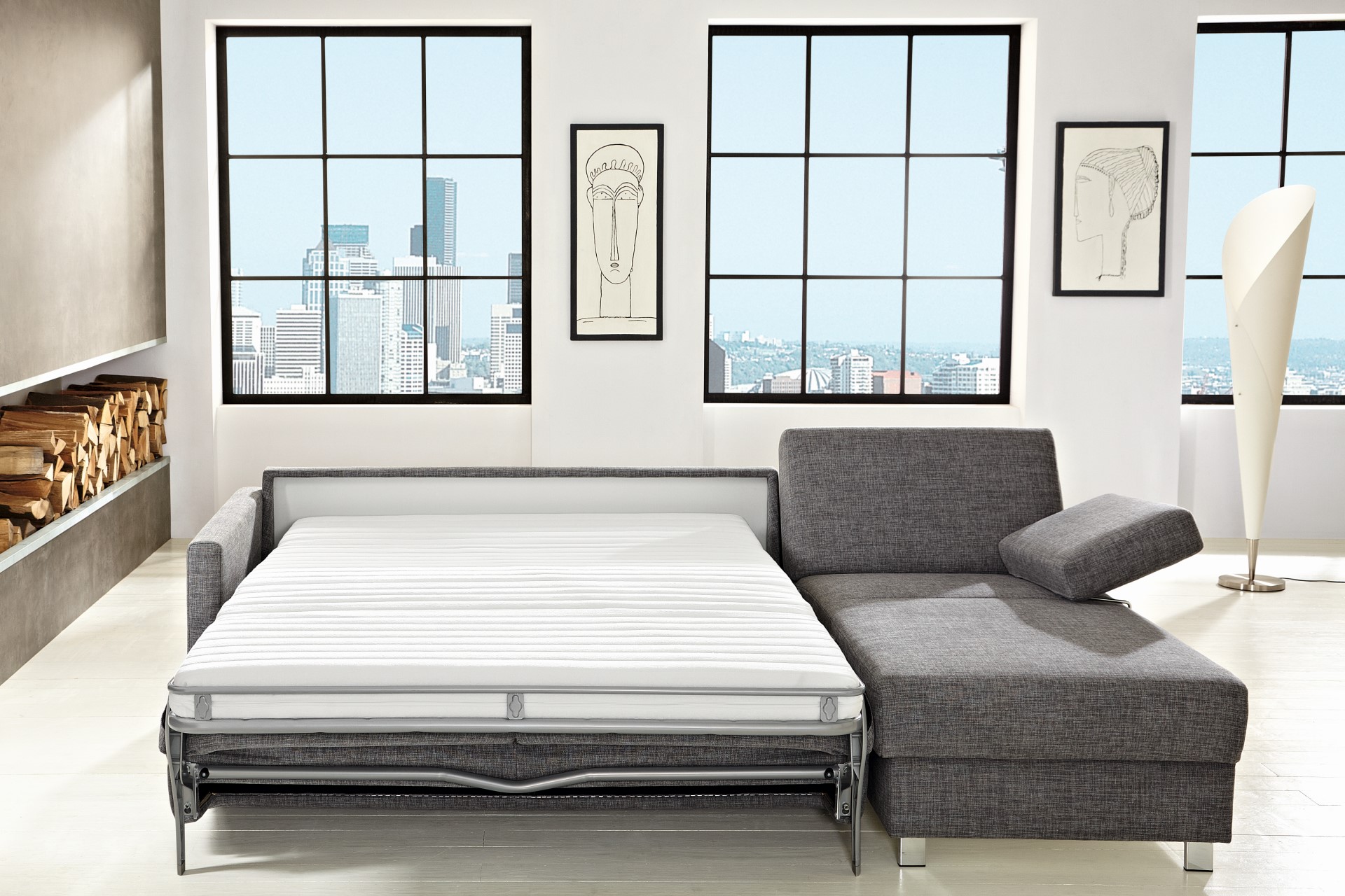 Ecksofa Maike der Marke Bali in Grau in einem minimalistisch eingerichteten Wohnzimmer mit umklappbarer Rückenlehne und Sitzfläche für eine Schlafoption mit echter Matratze und integriertem Lattenrost