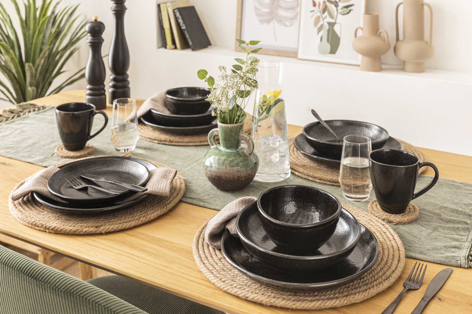 Die Geschirrserie Madeleine von Fürstenhof. Zu sehen ist ein gedeckter Holztisch mit schwarzen Tellern, Kaffeebechern und Schüsseln aus Steinzeug.
