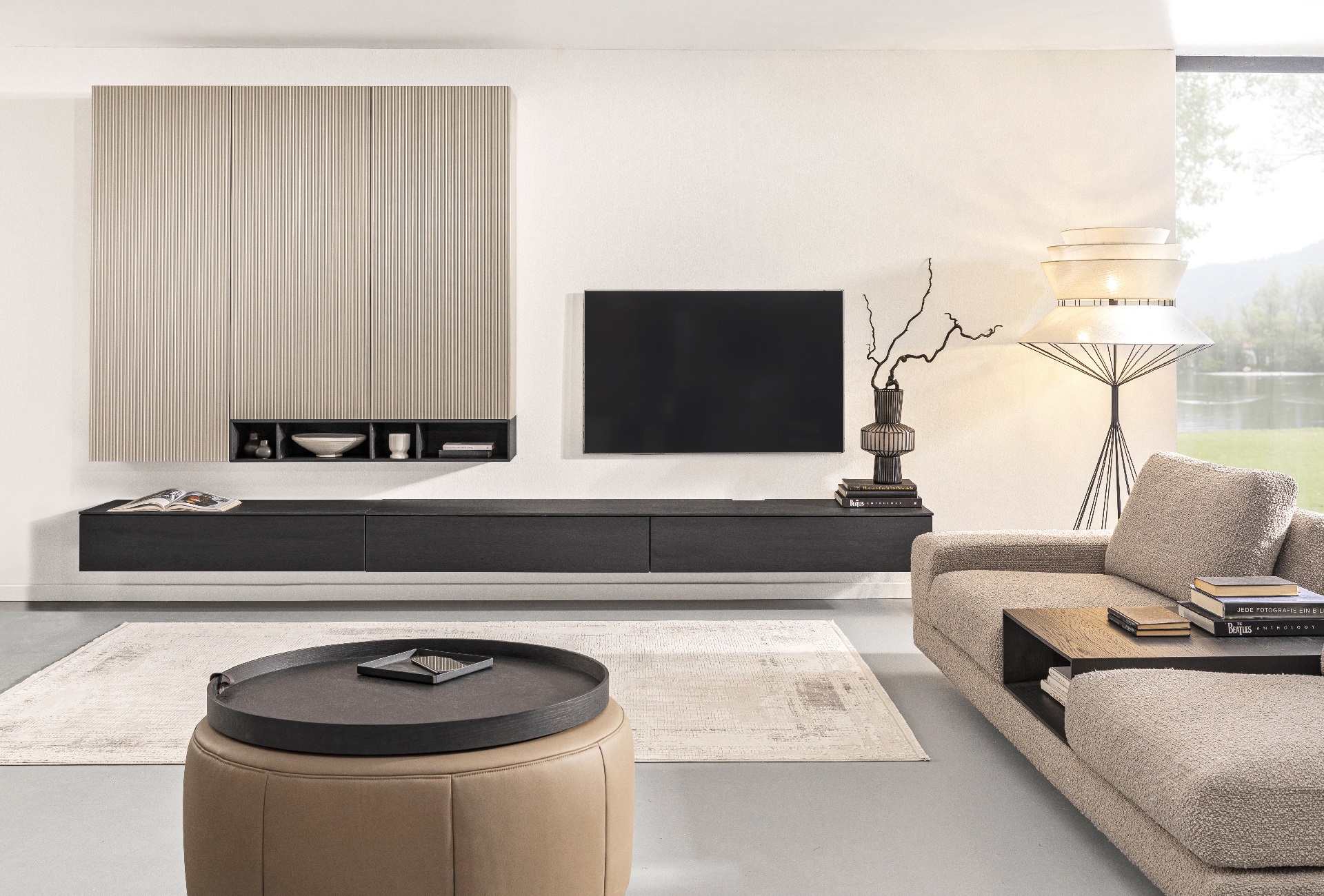 Modernes, helles Wohnzimmer der Marke Sormani mit minimalistischer Wohnwand, einem Sofa und Dekoelementen.