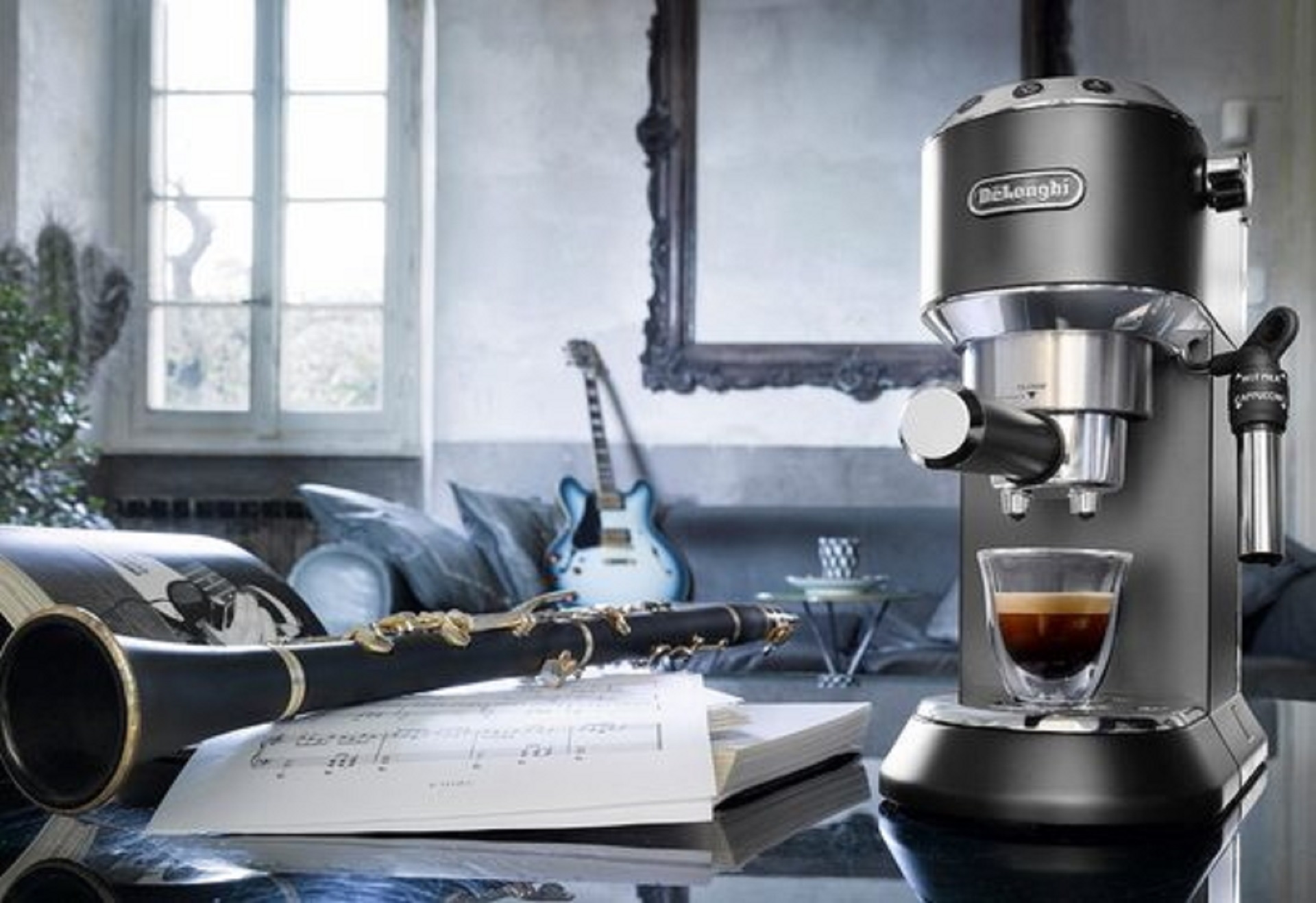 Kaffeemaschine Dedica aus dem Hause DeLonghi in einer Kombination aus Schwarz und Metall mit Siebträger in einem Arrangement mit Gitarre und Saxophon