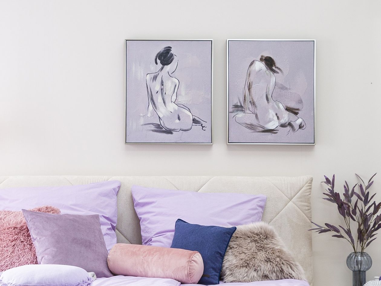 Wandbild Frau II aus grauem Leinen an einer Wand hängend über einem Bett in lavendelfarbener Gestaltung