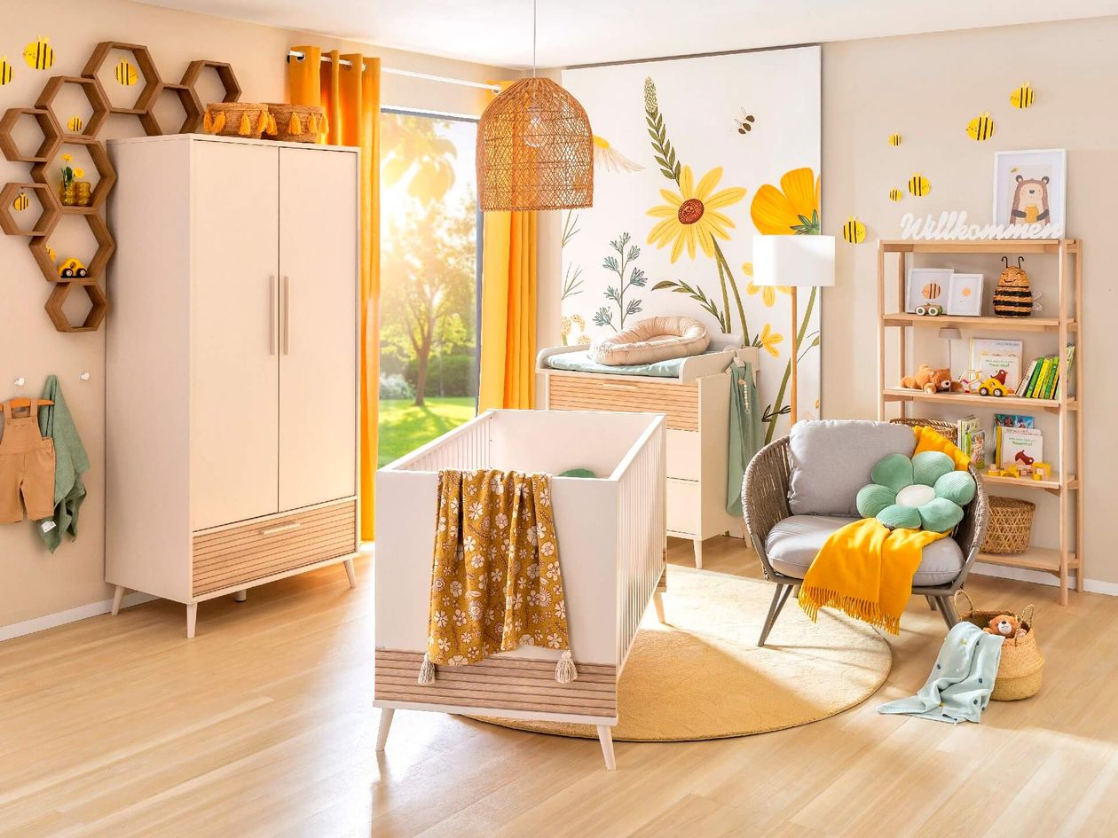Farbenfroh gestaltetes Babyzimmer mit hellen Möbeln und Bienchen-Motiven.