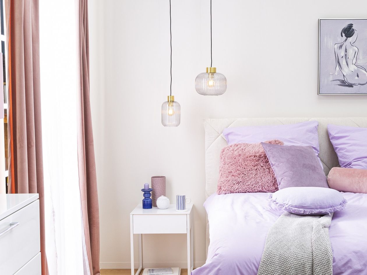 Pendelleuchte Mint der Marke Ideal Lux aus grauem Glas über einem Bett und einem Beistelltisch hängend