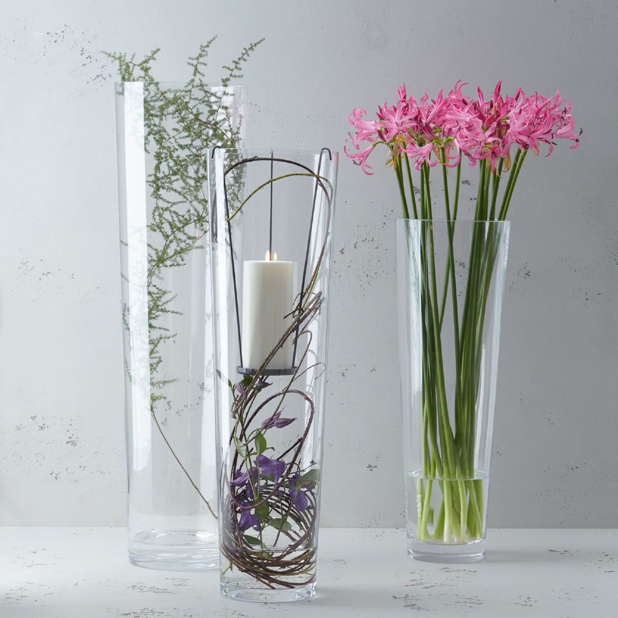 Vase in konischer Form in 70 cm Höhe aus transparentem Glas der Marke Leonardo in einem Arrangement mit zwei anderen Vasen mit Blumen gefüllt