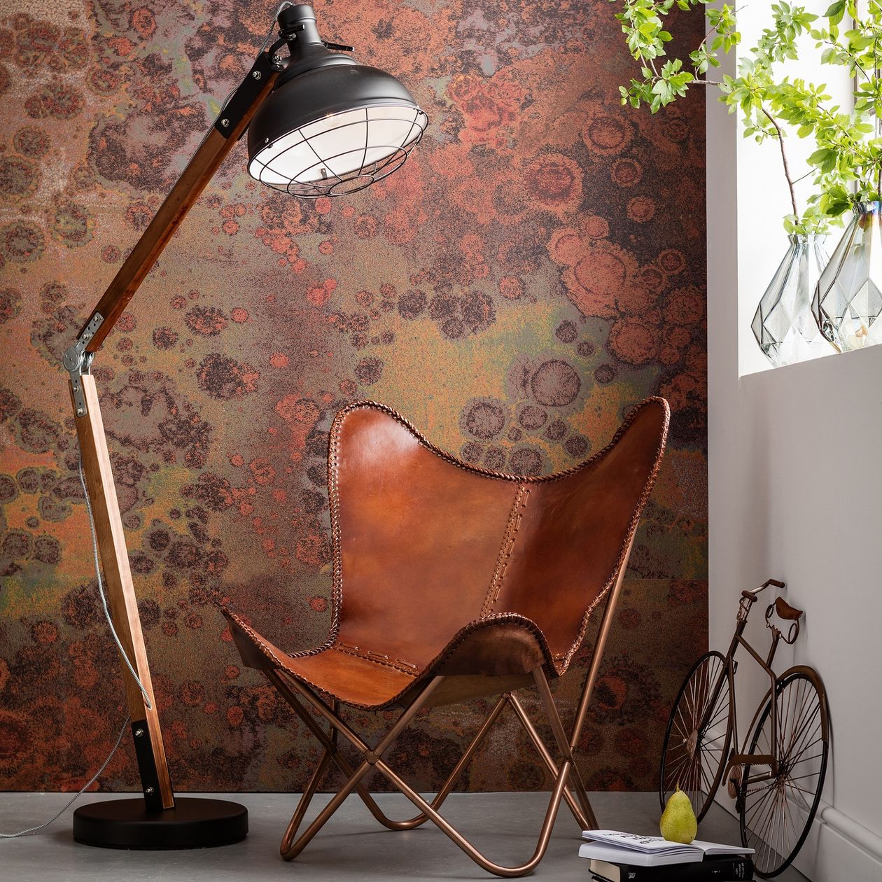 Sessel Butterfly aus dem Hause Kare Design aus braunem Leder in einer Ecke, die im Industrial Stil gestaltet ist.