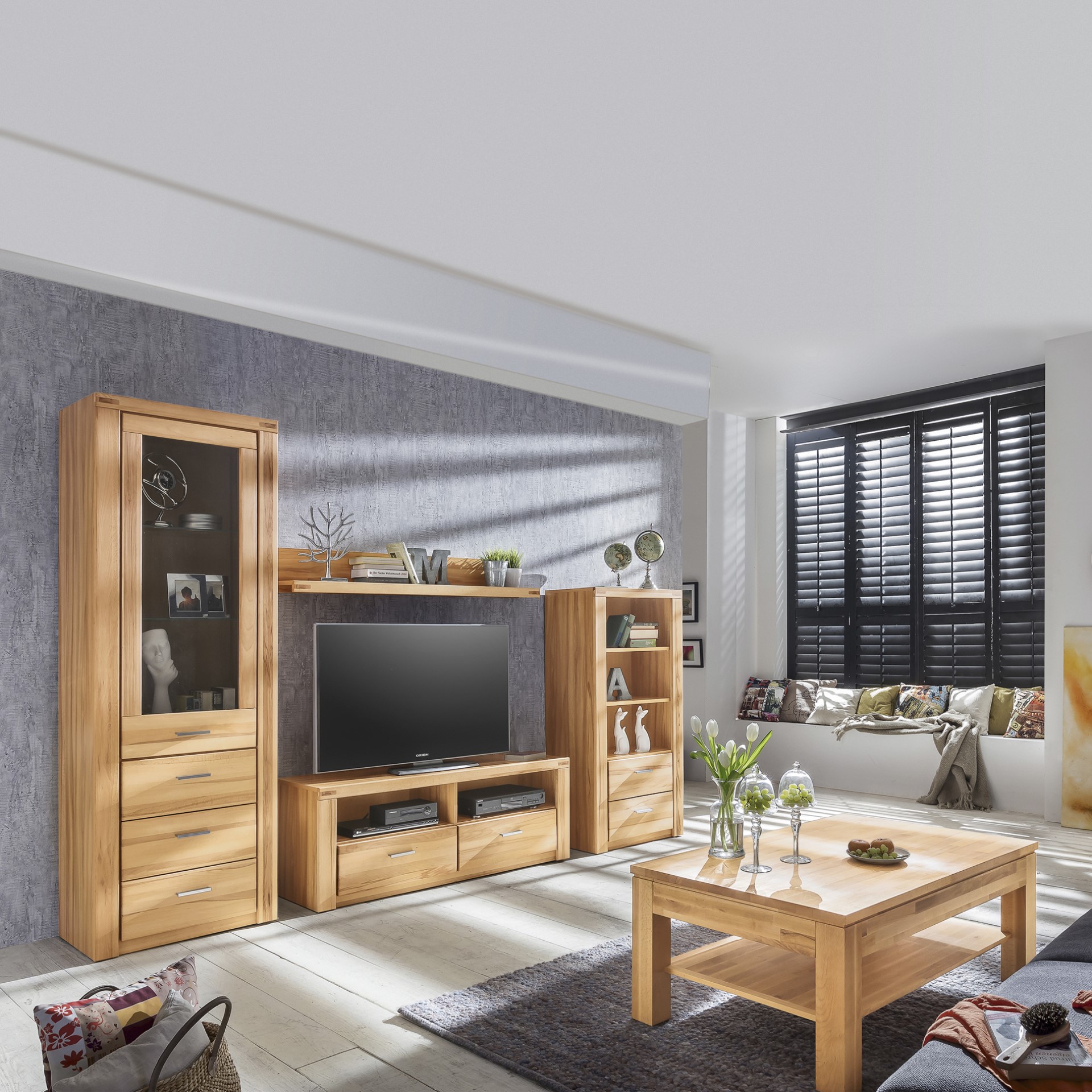 Modernes Wohnzimmer mit Holzmöbeln, darunter ein TV-Ständer, Regale und ein Couchtisch. Große Fenster, graue Wände und Dekorationsgegenstände vorhanden.