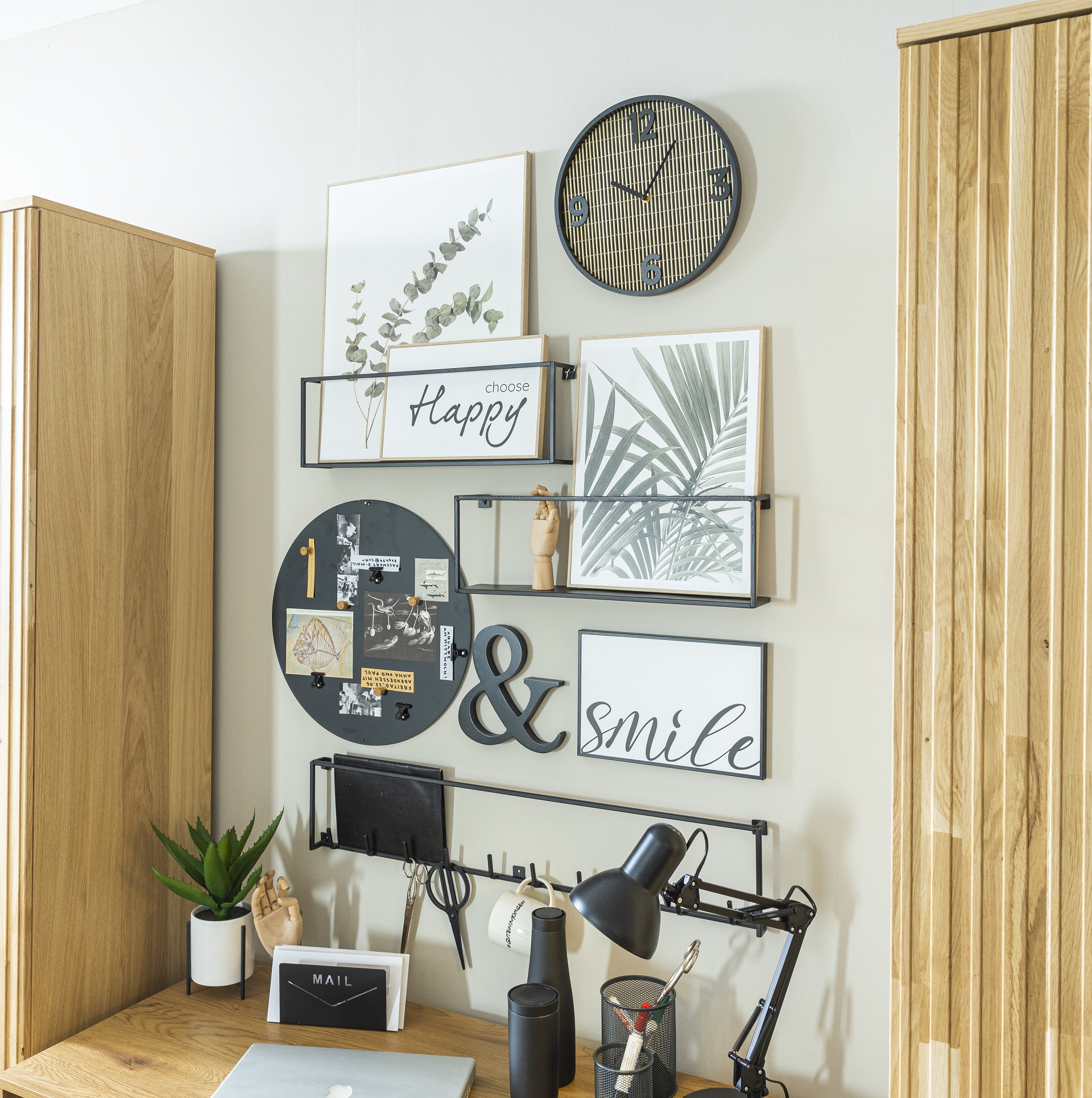 Das runde Memo Board Element in einer Größe von 44 cm aus schwarzem Stahl an einer dekorierten Wand über einem Schreibtisch