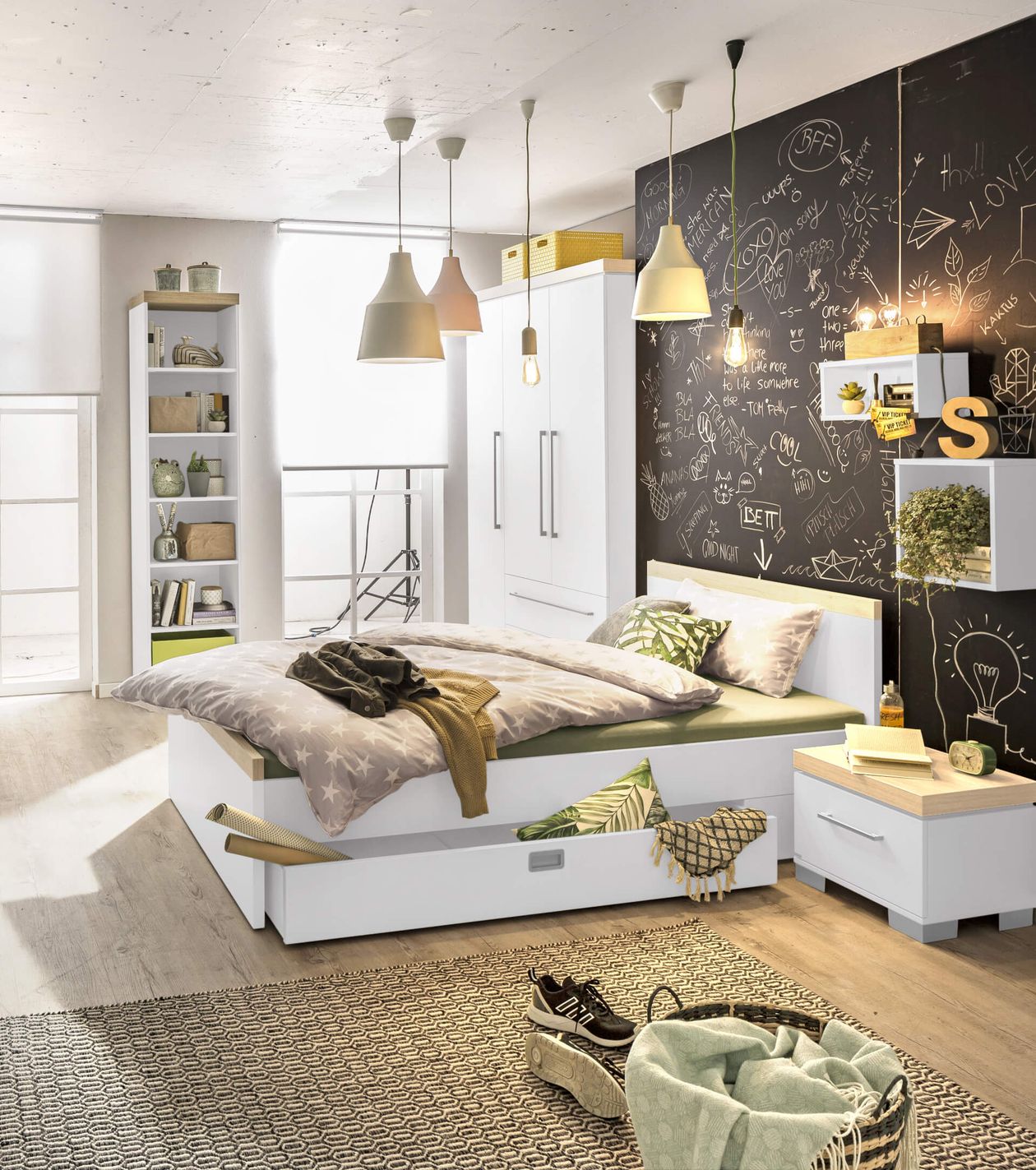 Modernes Schlafzimmer mit Kreidetafelwand, weißen Möbeln, grünen Akzenten und hängenden Lampen. Textilien und Dekoration verleihen Gemütlichkeit.