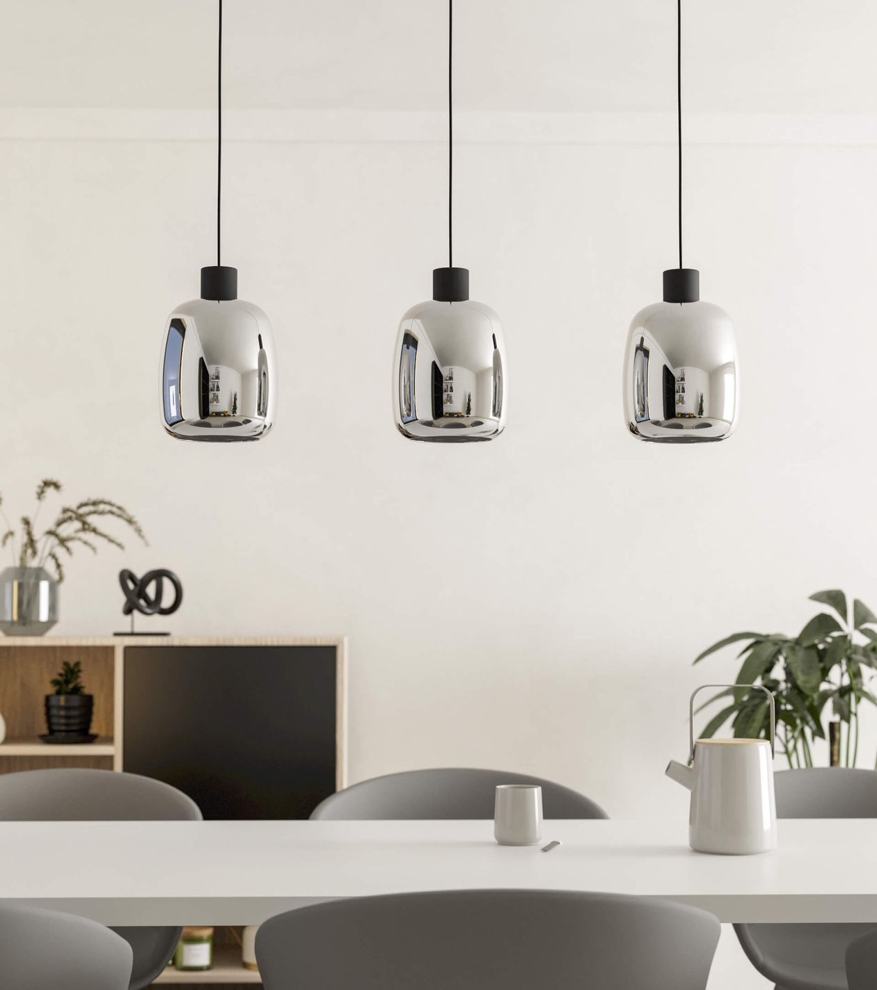 Moderne Pendelleuchte mit drei verspiegelten Glasschirmen setzt stilvolle Akzente über dem weißen Esstisch. Perfekt für ein edles, zeitgemäßes Wohnambiente.