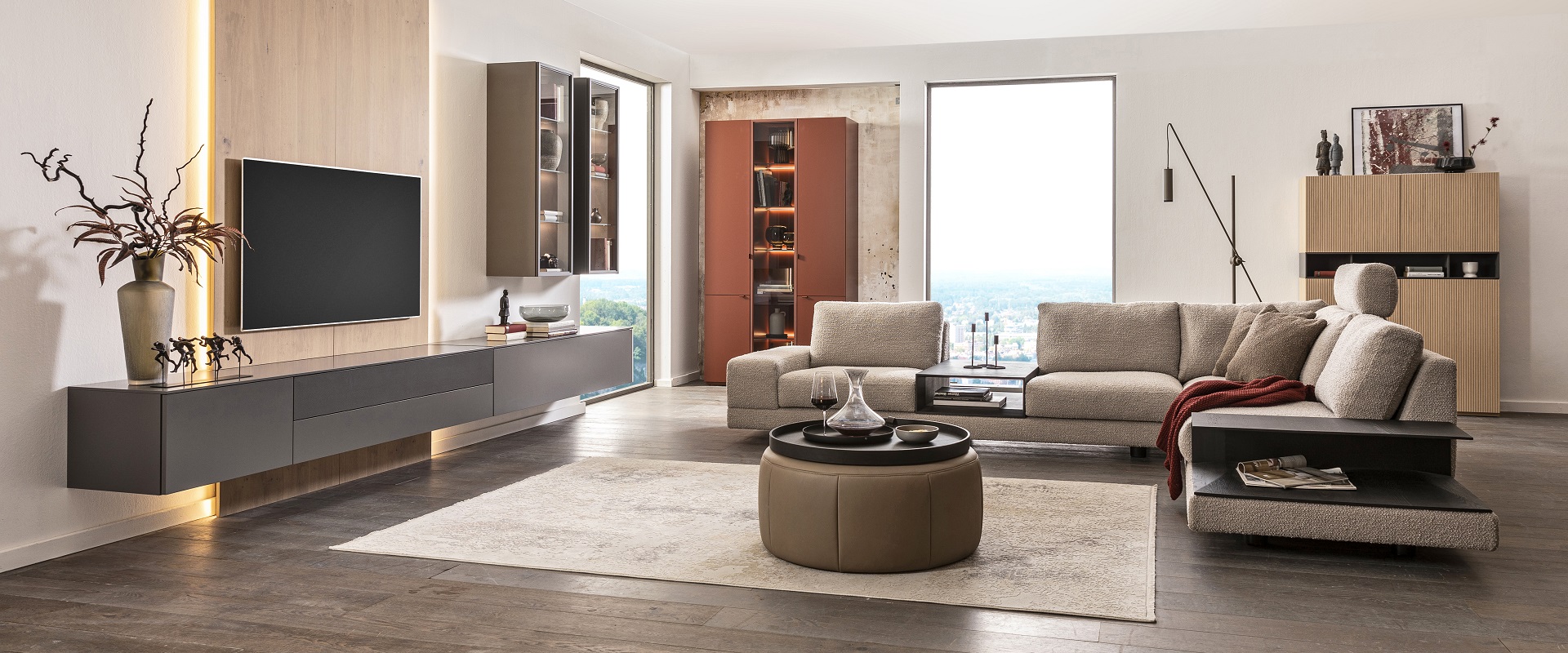 Modernes Wohnzimmer der Marke Sormani mit geradlinigen Möbeln in neutralen Farbtönen. Zwei große Fenster bieten einen städtischen Ausblick.