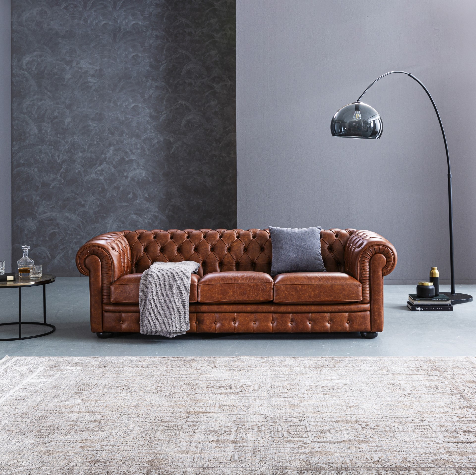 3-Sitzer Sofa Chester von Stilreich aus braunem Leder in einem minimalistisch gestalteten Wohnzimmer