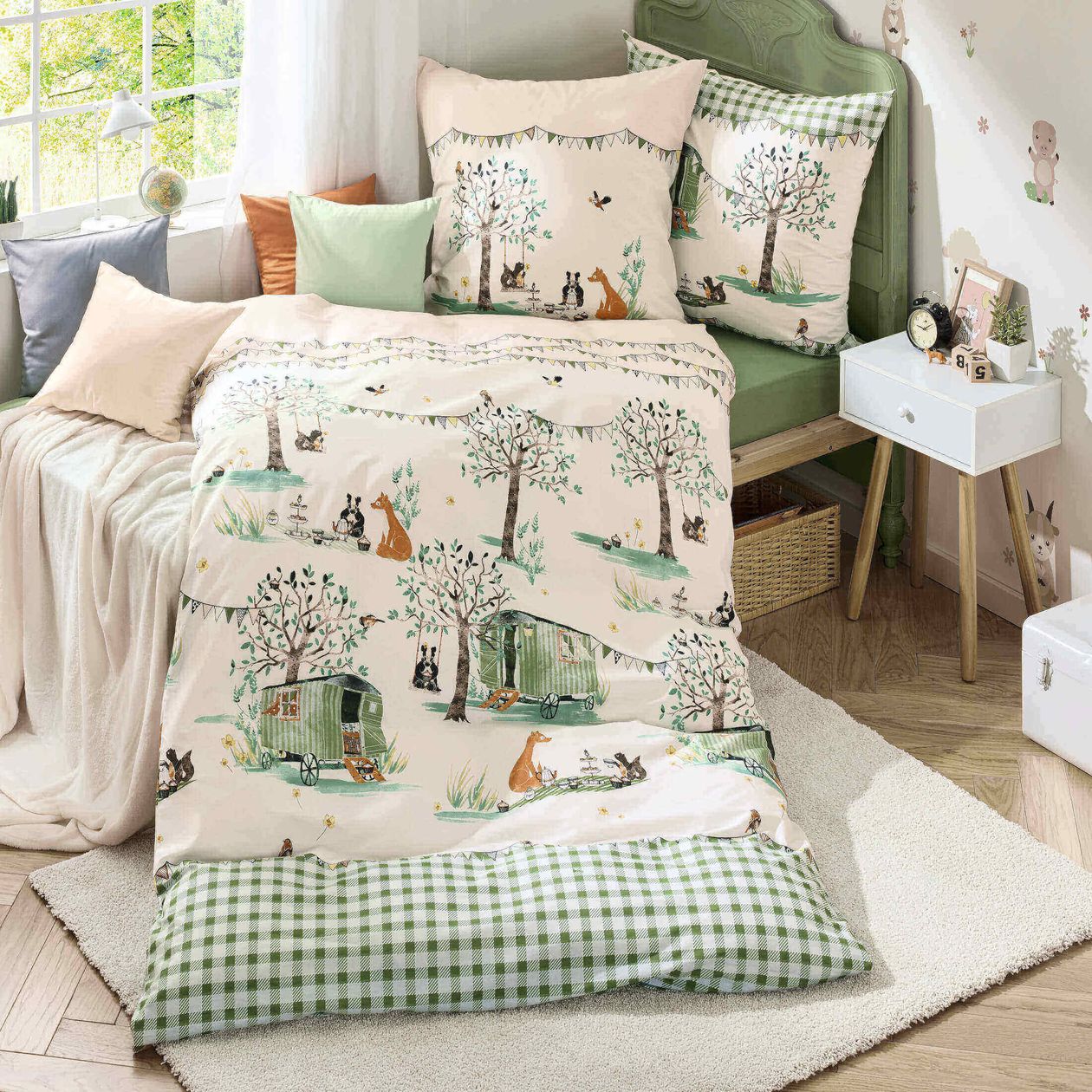 Gemütliches Schlafzimmer mit Bettwäsche im Naturmotiv, dekoriert mit Bäumen, Fuchsmotiven und Wohnwagen; Kissen in sanften Pastellfarben.
