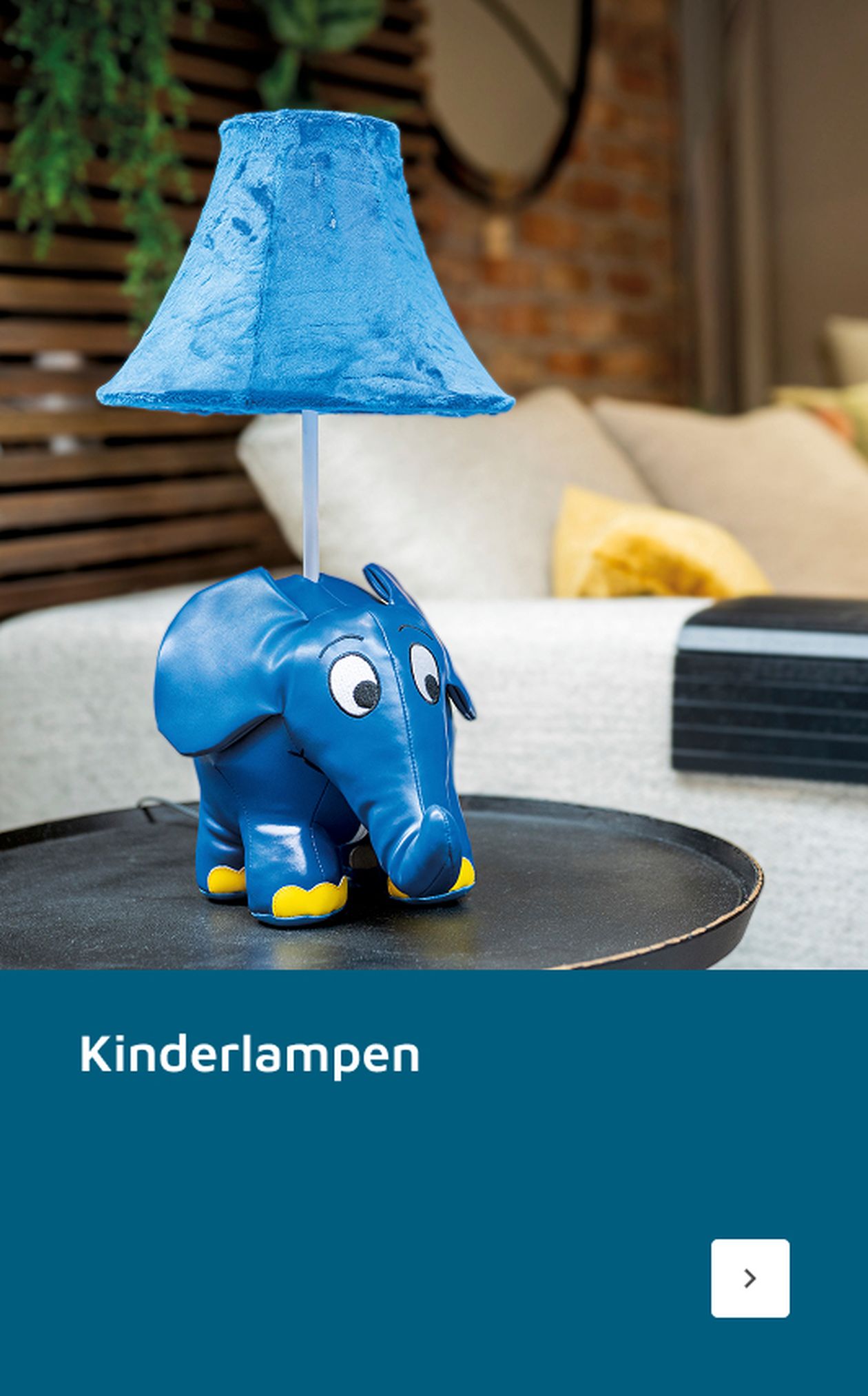 Blaue Lampe in Elefantenform mit Stoffschirm auf einem Tisch in einem gemütlichen Zimmer. Der Text darunter lautet „Kinderlampen“.
