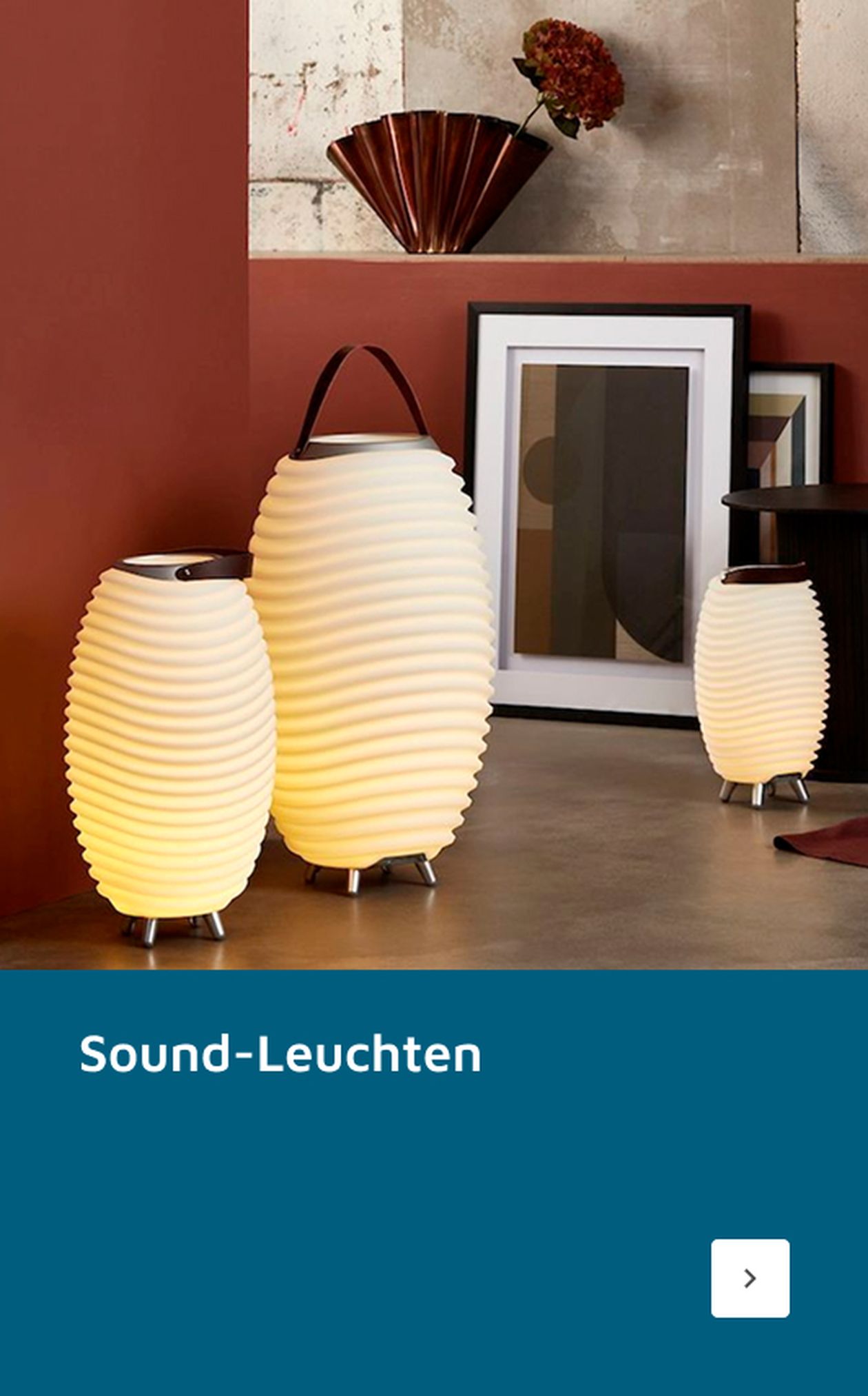 Drei gerippte, ovale Lampen unterschiedlicher Größe strahlen in einem modernen Raum mit Kunst und Dekor ein warmes Licht aus. Der Text lautet „Sound-Leuchten“.