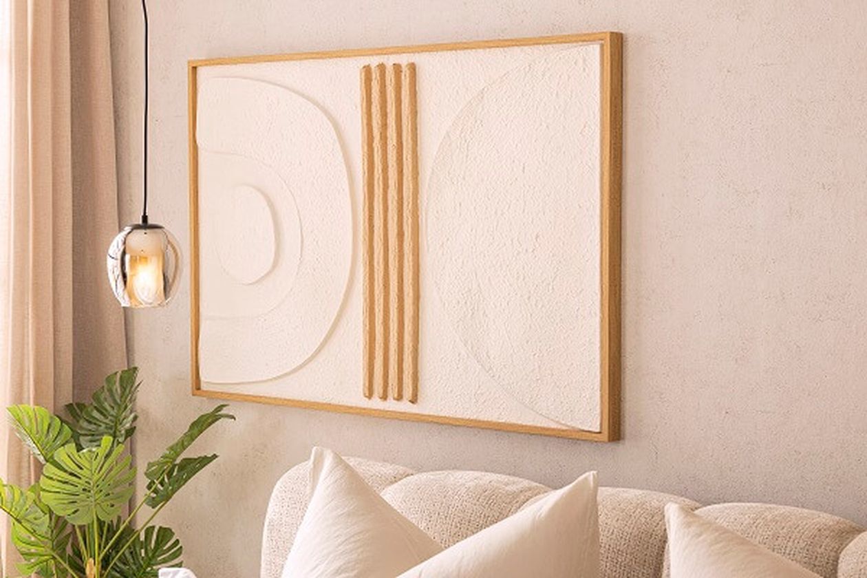 Helles Wandbild mit Holz neben einer Pendelleuchte.