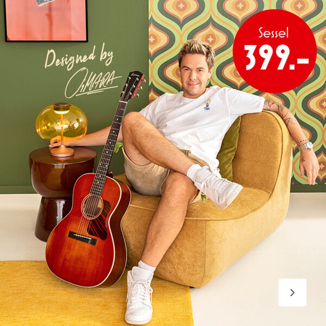 Mann in Freizeitkleidung sitzt auf einem braunen Stuhl mit einer Gitarre neben sich vor einer Wand mit Retro-Muster. Auf dem roten Preisschild steht „Sessel 399.-“.