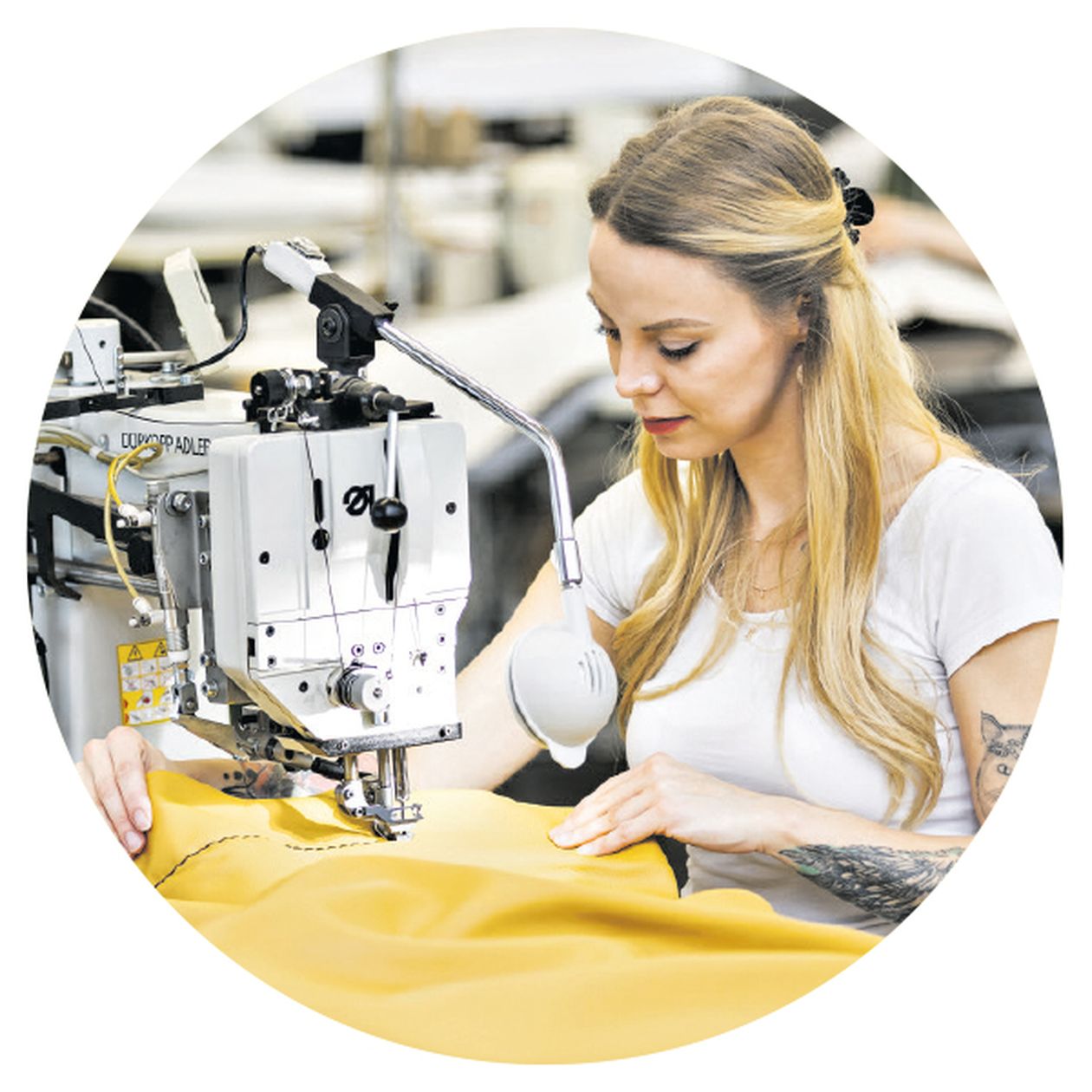 Bild: Eine Näherin schneidert einen Sofabezug an der Nähmaschine.