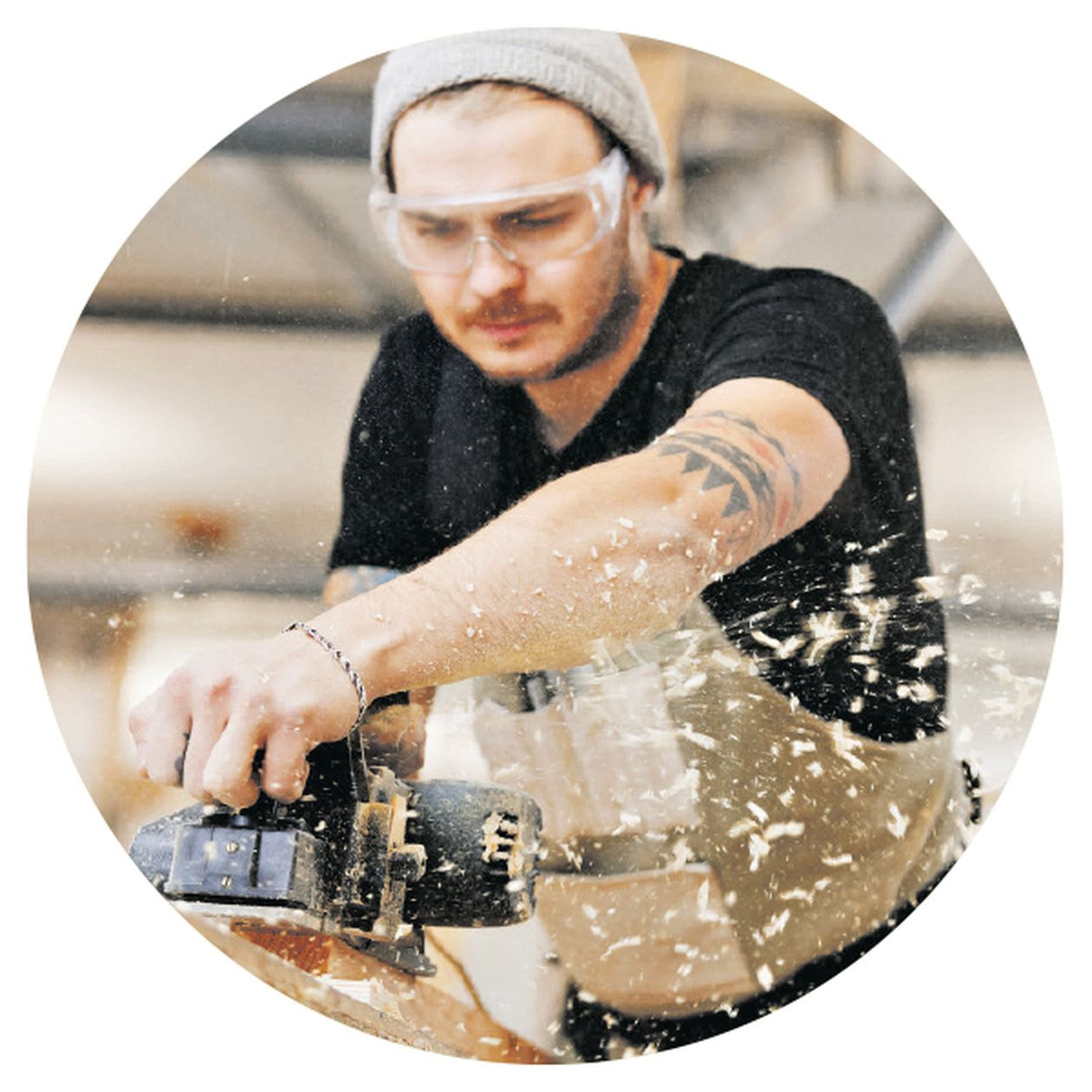 Bild: Ein Handwerker hobelt Holz mit mit einem Werkzeug