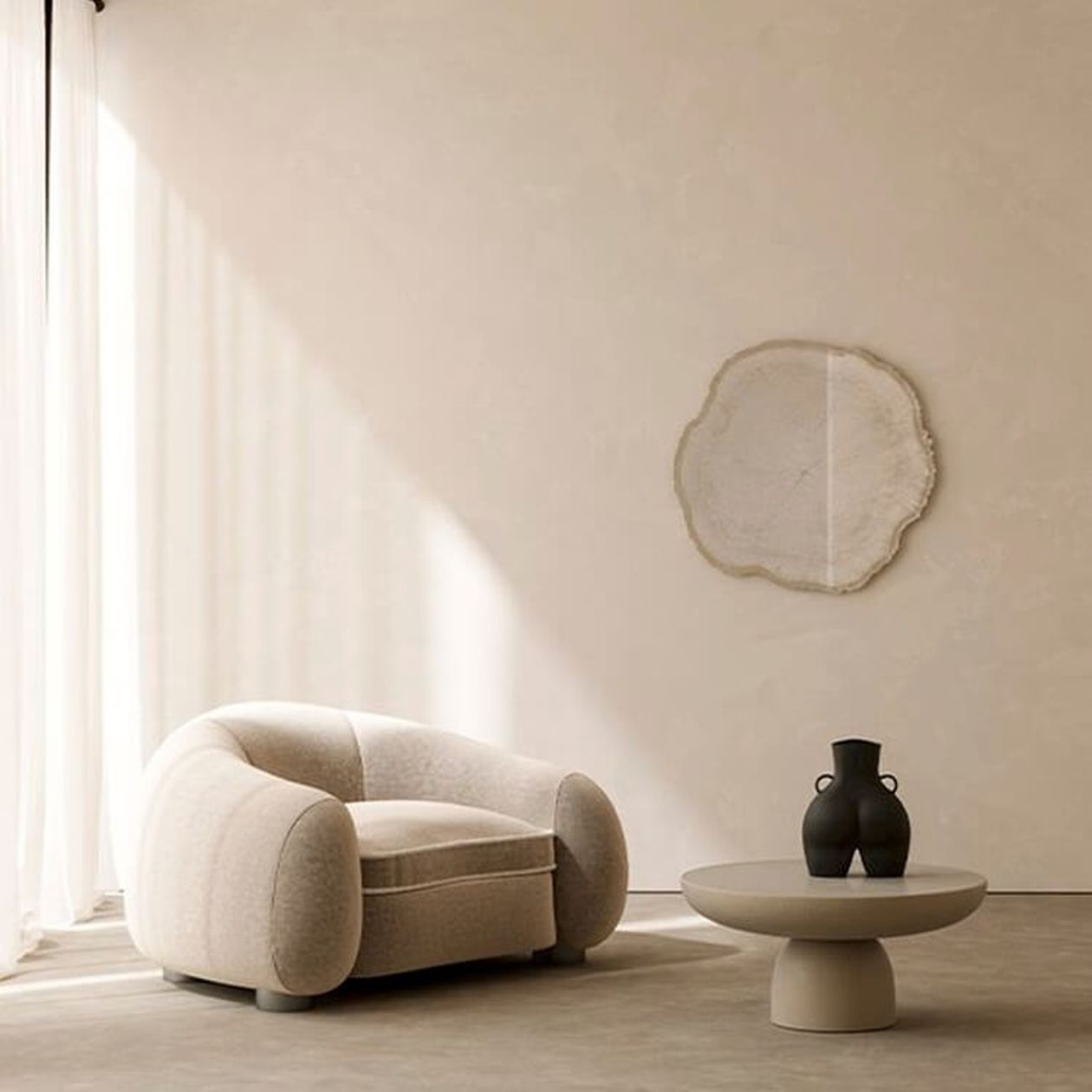 Wohnzimmer im Wabi-Sabi-Stil mit einem organisch geformten Wandspiegel mit welligem, naturbelassenem Rahmen in Beige an einer hellen Putzwand. Davor ein cremefarbener, rundlicher Sessel mit geschwungenen Formen sowie ein niedriger, runder Beistelltisch in Sandton mit zwei dunklen Keramikvasen. Im Hintergrund fällt weiches Licht durch einen transparenten weißen Vorhang.