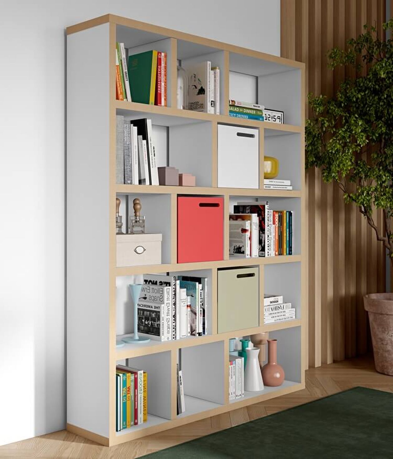 Ein modernes Bücherregal mit verschiedenen Büchern, farbenfrohen Aufbewahrungsboxen und Dekoartikeln. Daneben steht eine Topfpflanze auf einem Holzboden.