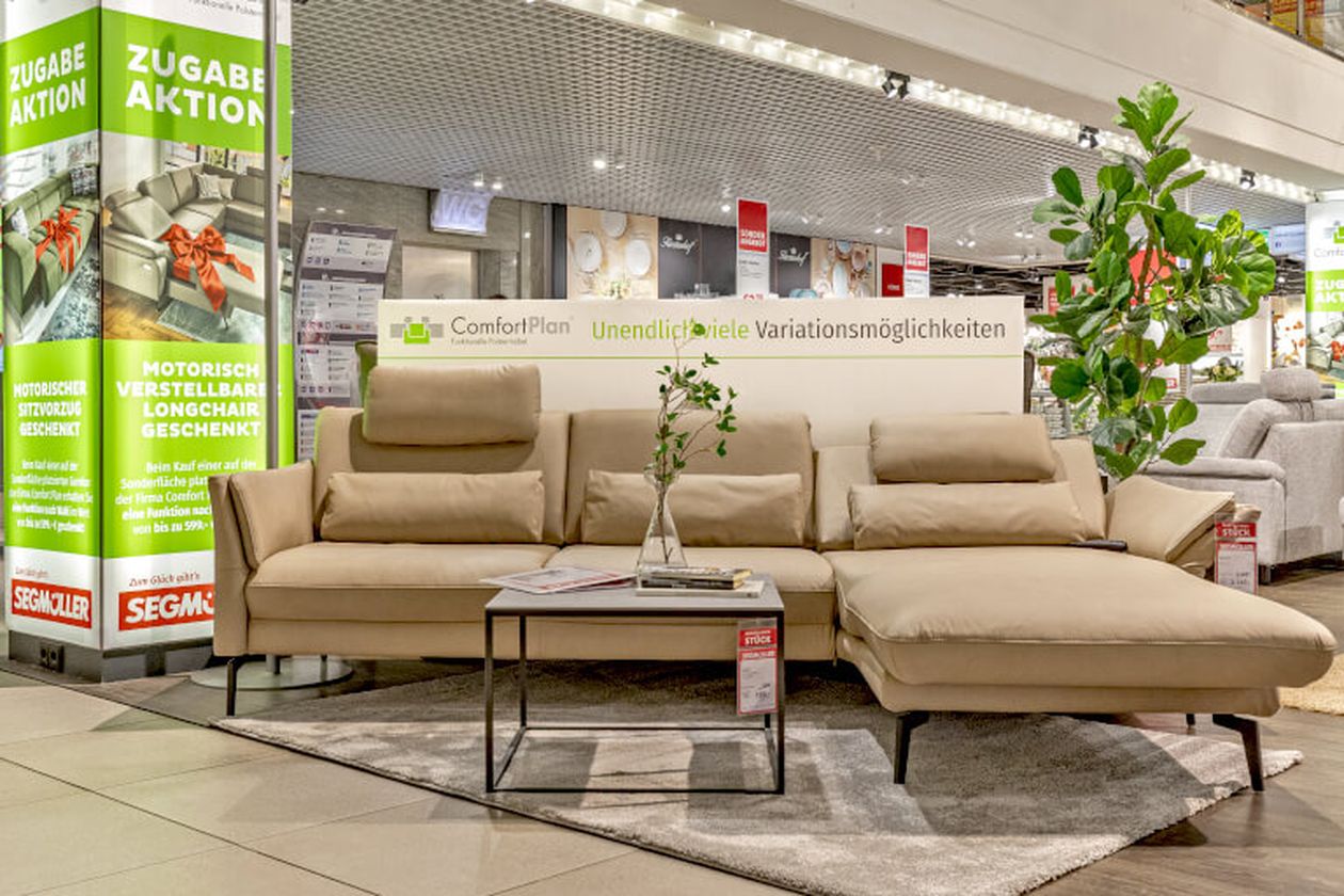 Sofalandschaft in einem Möbelgeschäft dekoriert mit Tisch und Pflanzen.