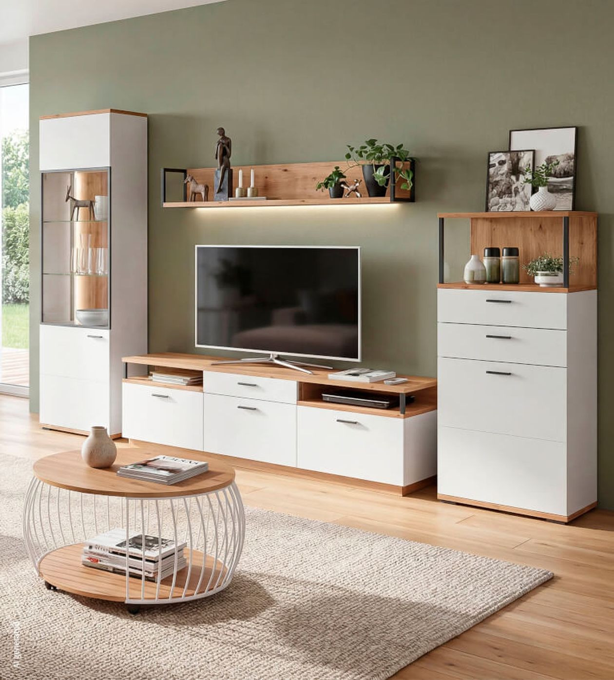 Moderner Wohnraum mit hellen Möbeln: TV, Regale, Vitrine, Couchtisch aus Holz und Weiß, grüner Wandfarbe, Dekoration und Teppichboden.