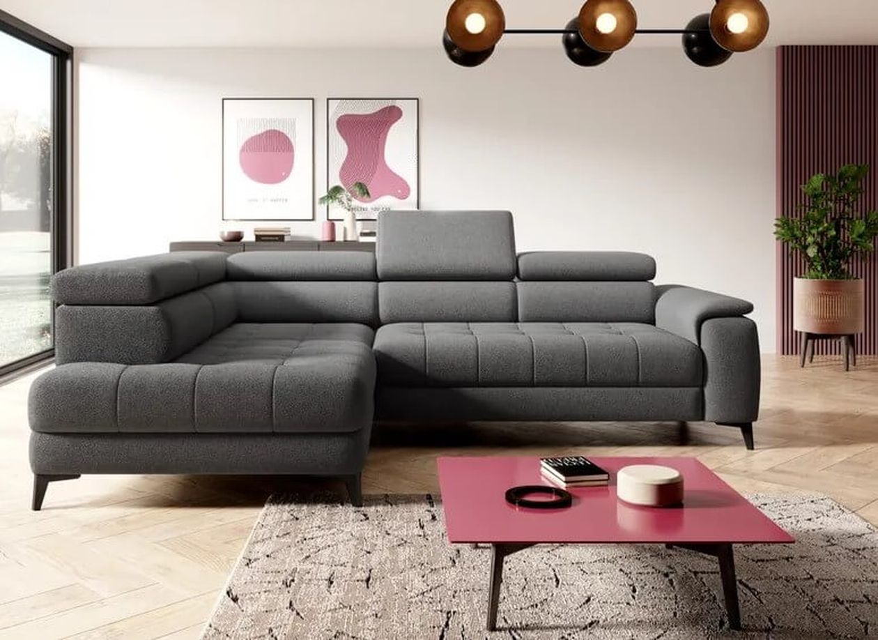 Modernes Wohnzimmer mit einem grauen Sofa, einem rosa Couchtisch, abstrakter Kunst und einer Topfpflanze. Großes Fenster und geometrische Leuchte darüber.