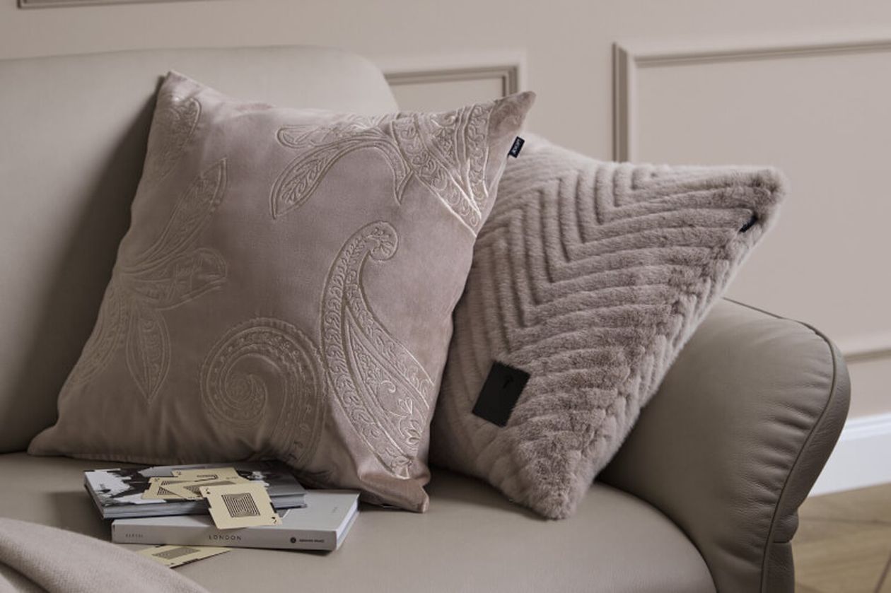 Produktbild: Kissenbezüge der Marke JOOP! auf einem Sofa in einem hell gehaltenen Wohnzimmer.