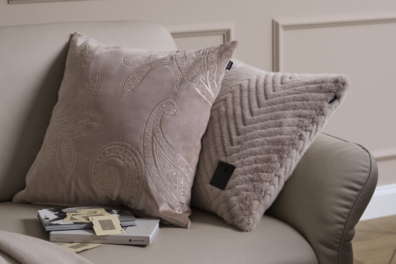 Produktbild: Kissenbezüge der Marke JOOP! auf einem Sofa in einem hell gehaltenen Wohnzimmer.