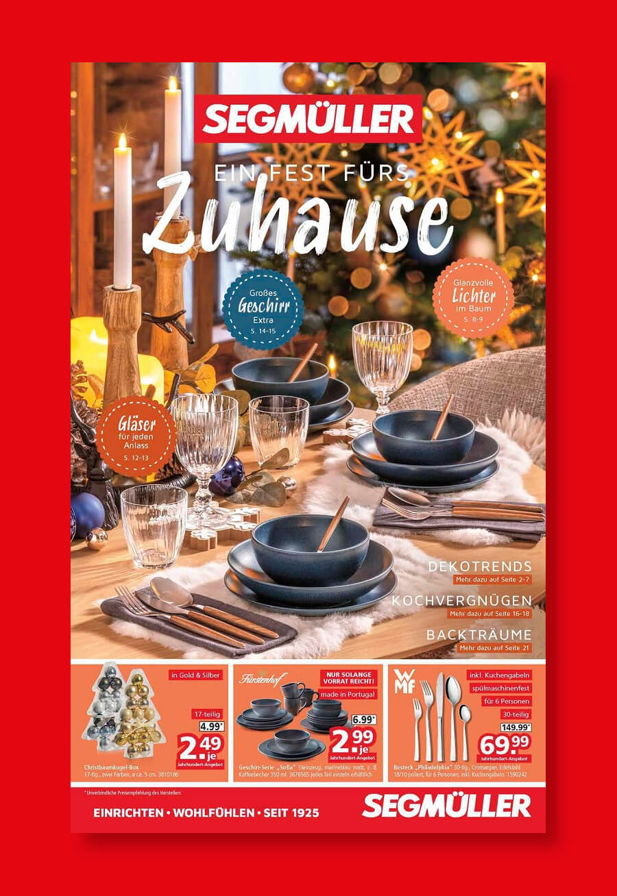Titel eines Prospekts mit festlicher Tischdekoration mit schwarzem Geschirr, Kerzen und Weihnachtsdekoration auf einem Holztisch. Text "Ein Fest fürs Zuhause" und Segmüller-Branding.