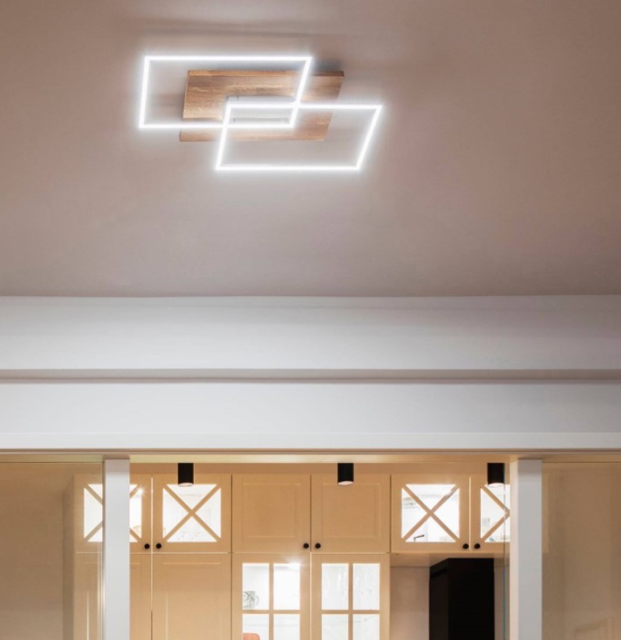 Eine Deckenleuchten mit zwei quadratischen LED-Leuchten hängt an der Decke. Die Leuchten sind an einem Holzelement befestigt.
