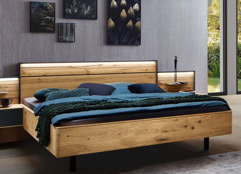 Modernes Schlafzimmer mit einem Holzbett, blaugrüner Bettwäsche und Wandkunst zum Thema Natur. Ein großes Fenster auf der rechten Seite lässt natürliches Licht herein.