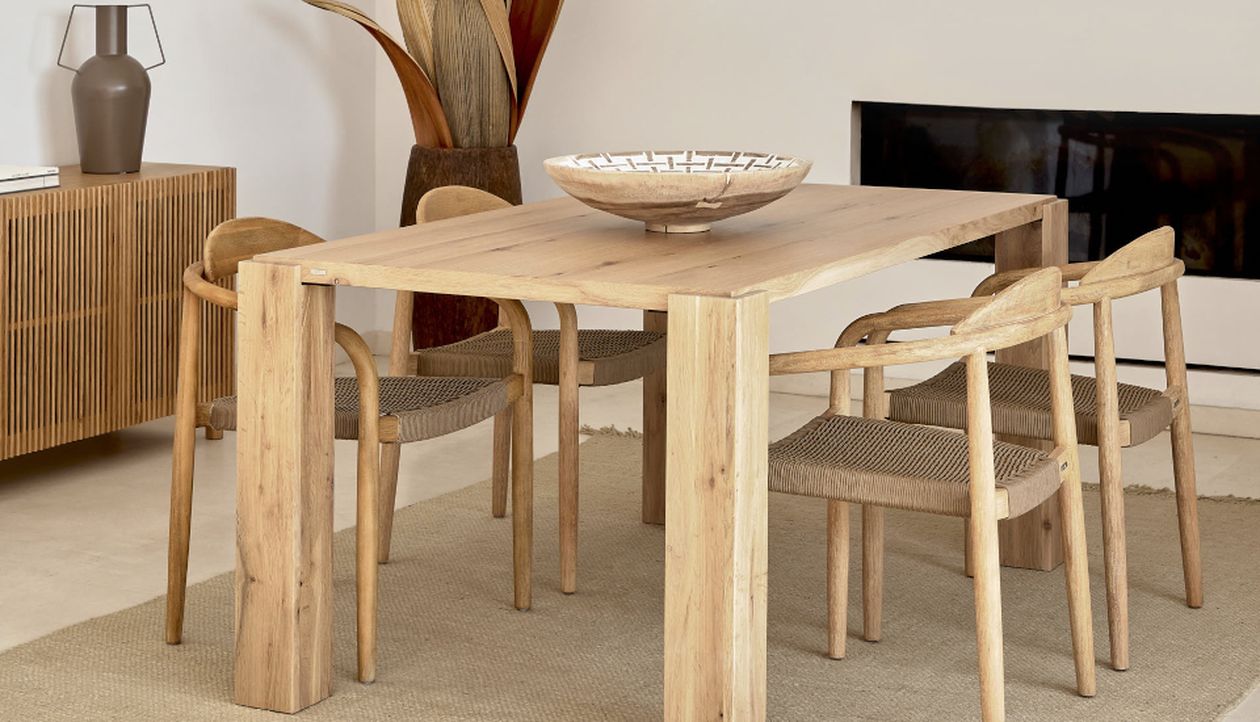 Minimalistisches Esszimmer mit Holztisch, vier passenden Stühlen, einer dekorativen Schale und einem Sideboard. Neutrale Farbtöne und natürliche Texturen.