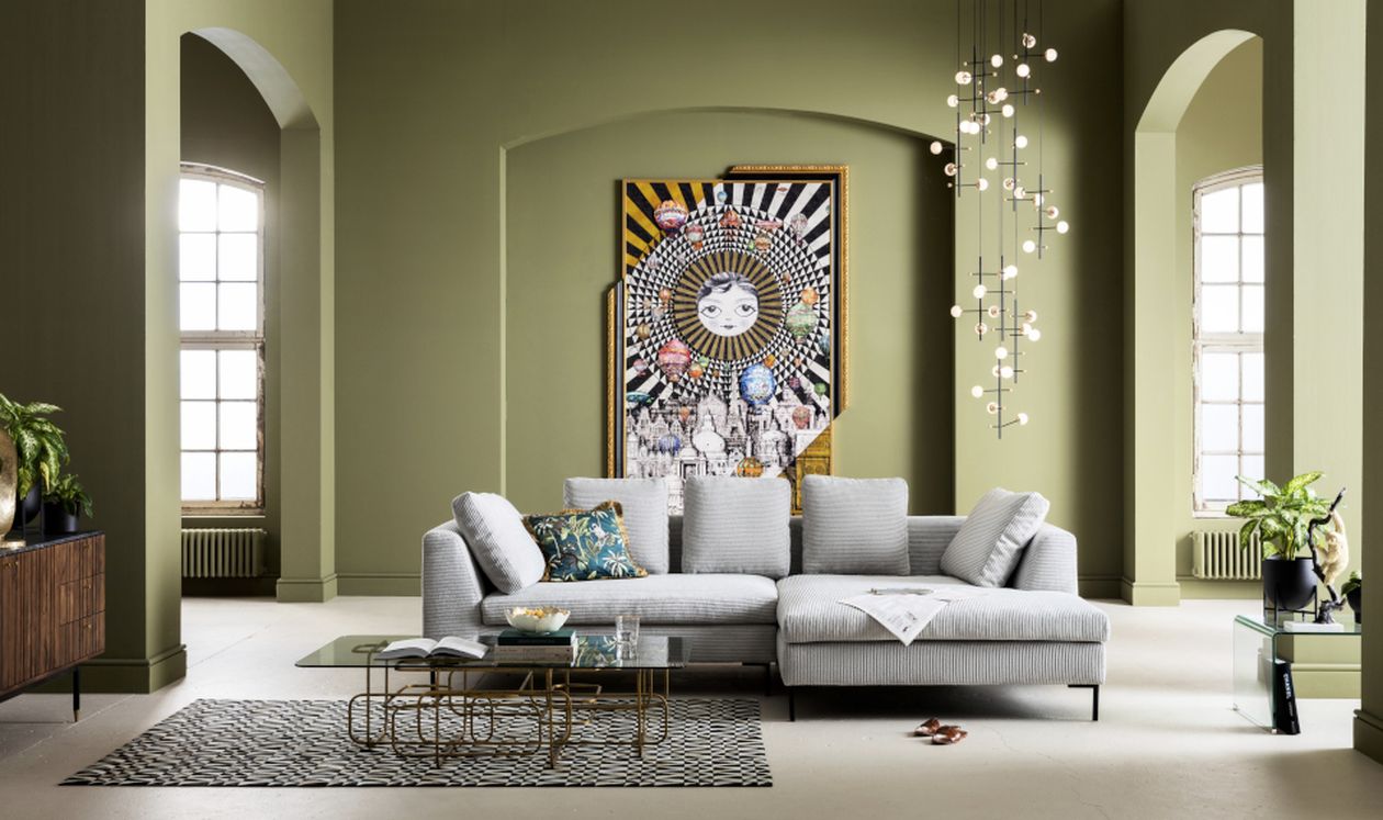 Modernes Wohnzimmer: graues Ecksofa, schwarzer Couchtisch, Pendelleuchte und farbenfrohes Wandbild mit abstraktem Motiv.