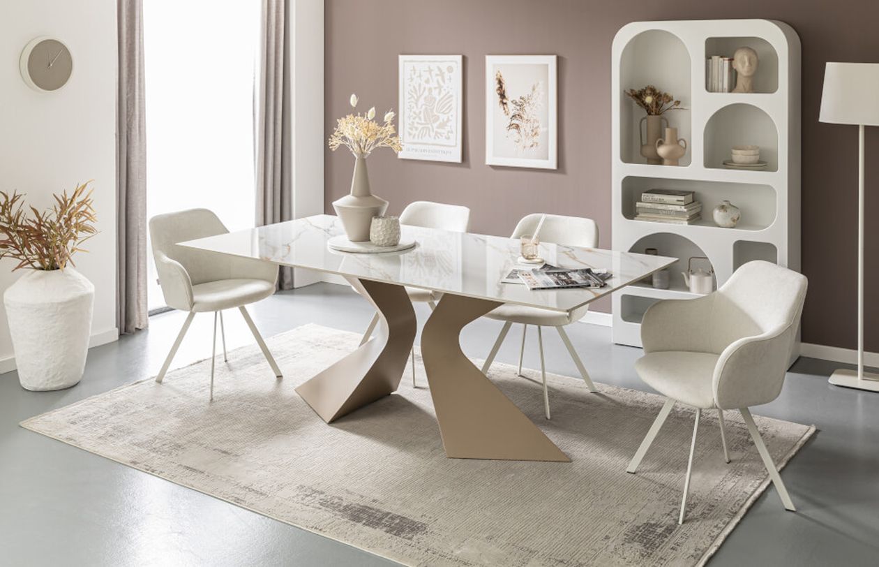 Moderner Essbereich mit einem Glastisch auf einem beigen Teppich, umgeben von vier weißen Stühlen. Zur Dekoration gehören Pflanzen und minimalistische Wandbilder.