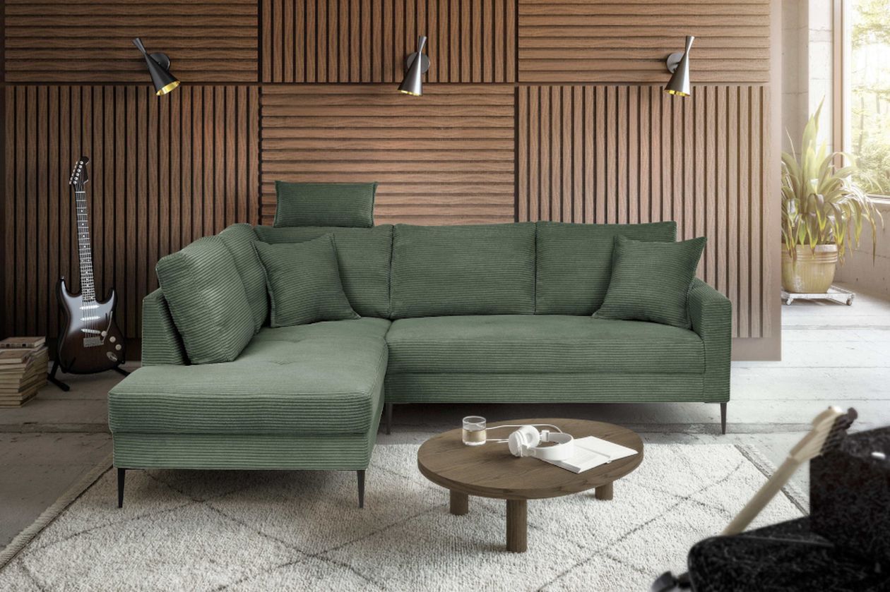 Modernes Wohnzimmer mit dunkler Holzvertäfelung, grüner Eckcouch und rundem Holztisch. E-Gitarre, Pflanzen und zwei Wandlampen ergänzen den Raum.