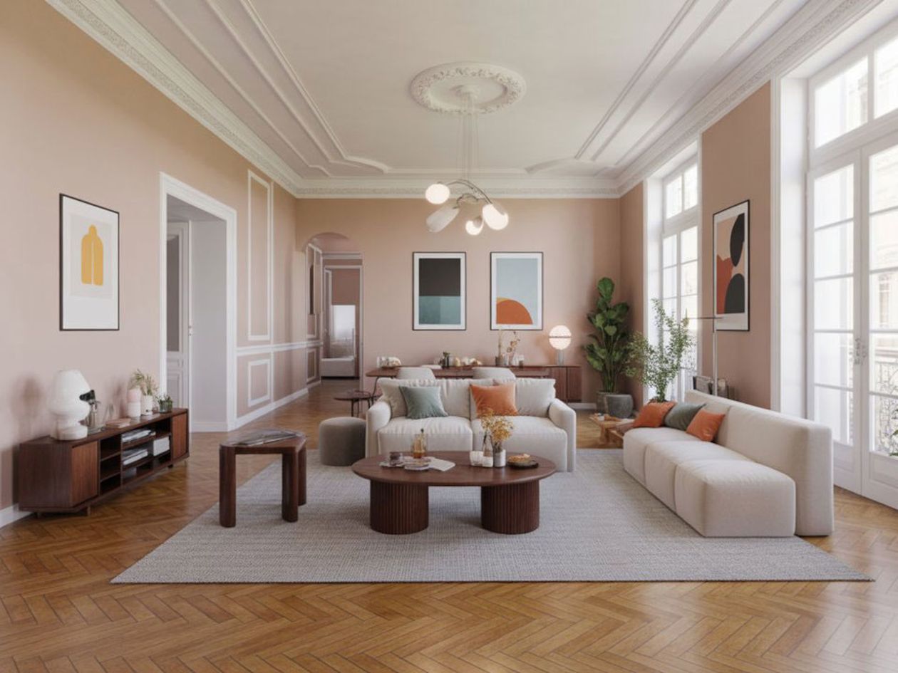 Großzügiges Wohnzimmer mit eleganter Einrichtung, bestehend aus einem großen beigen Sofa, Holztischen, moderner Kunst und einem Fischgrätparkett.